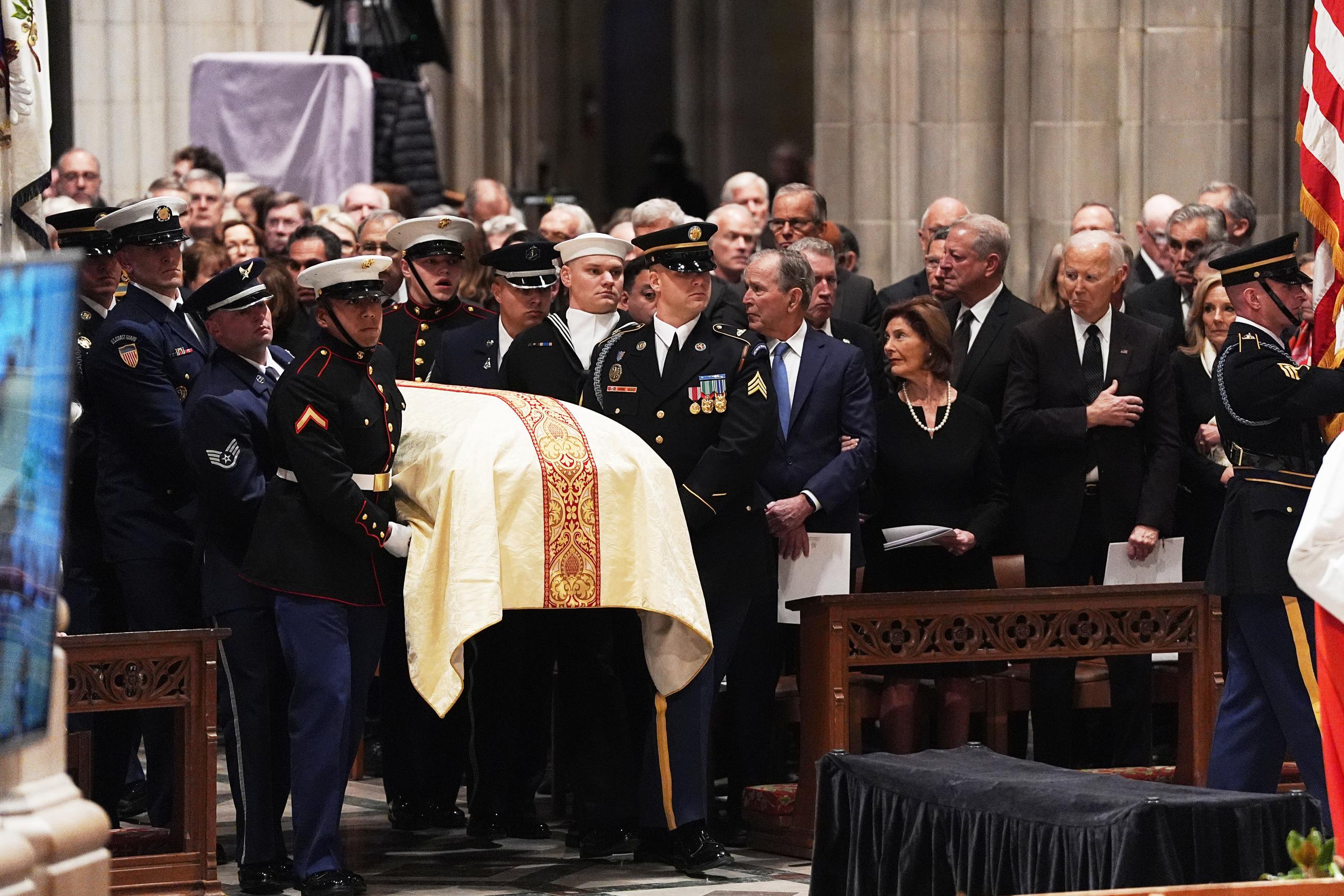 George W. Bush, Laura Bush, Joe Biden, and Jill Biden look on as Cheney's casket arrives at Washington National Cathedral. (AP Photo/Matt Rourke)