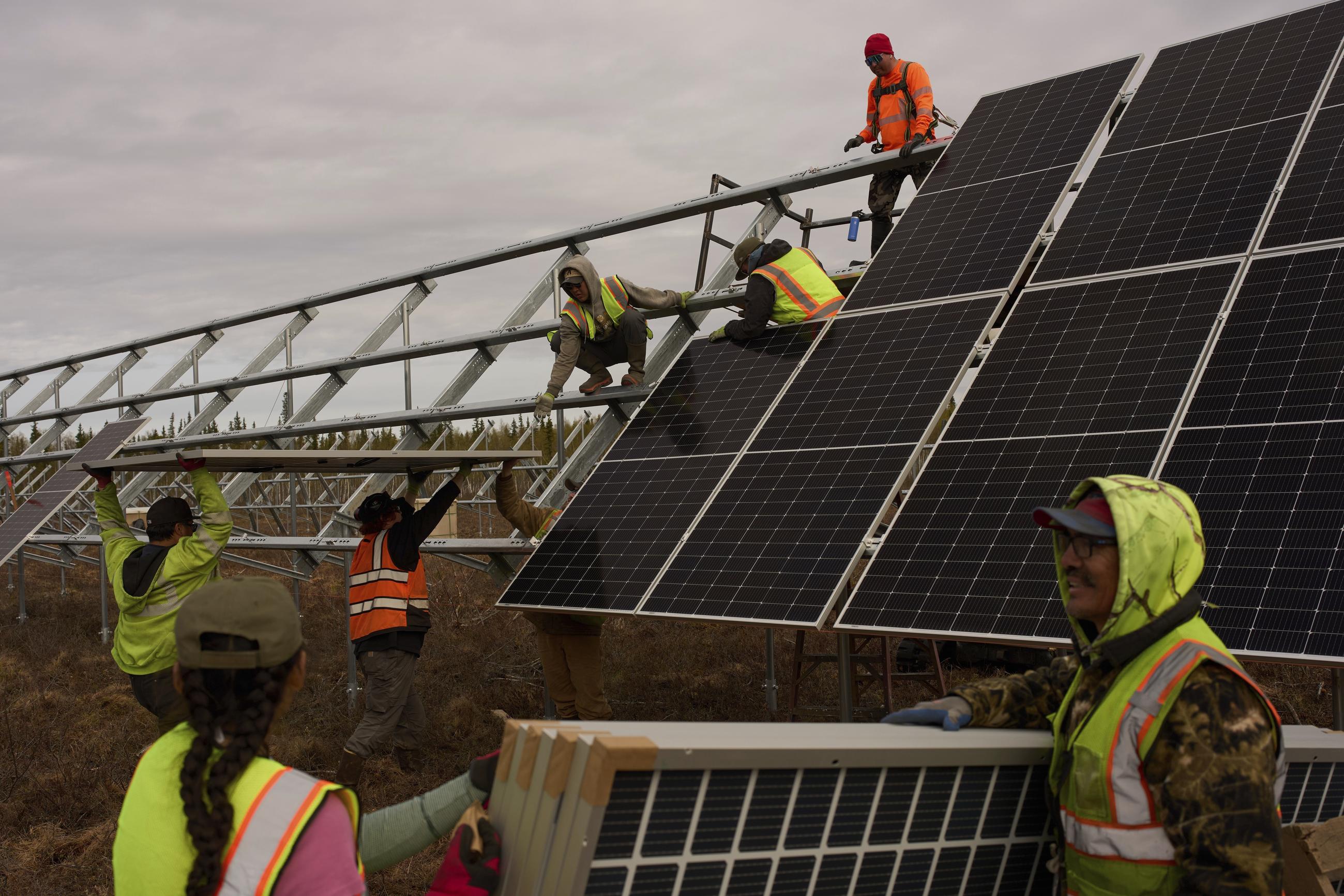 Workers install panels for a solar project in Galena, Alaska, in May. (AP Photo/John Locher)