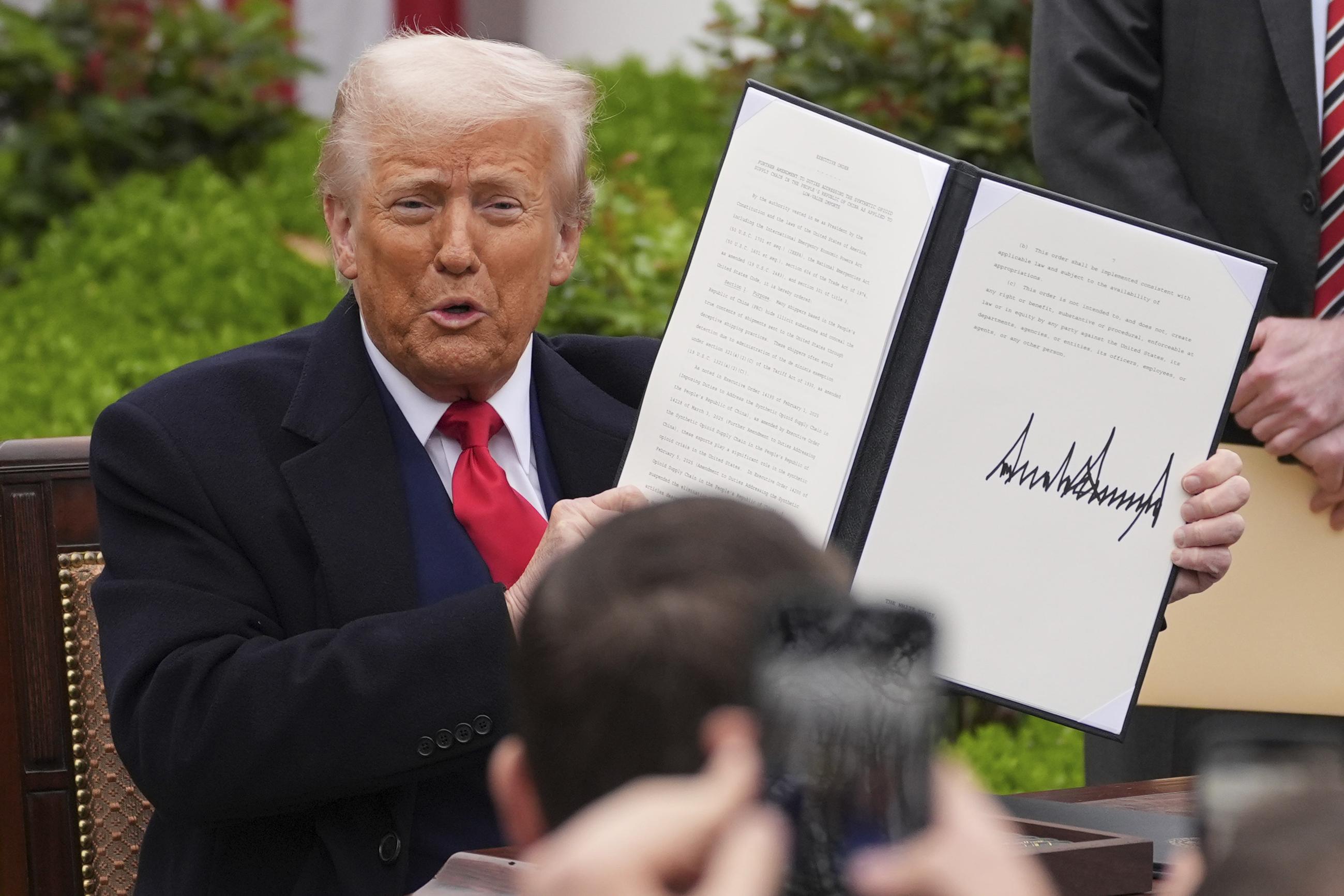 President Trump holds a signed executive order during an event to announce new tariffs in the Rose Garden of the White House on April 2. (AP Photo/Evan Vucci)
