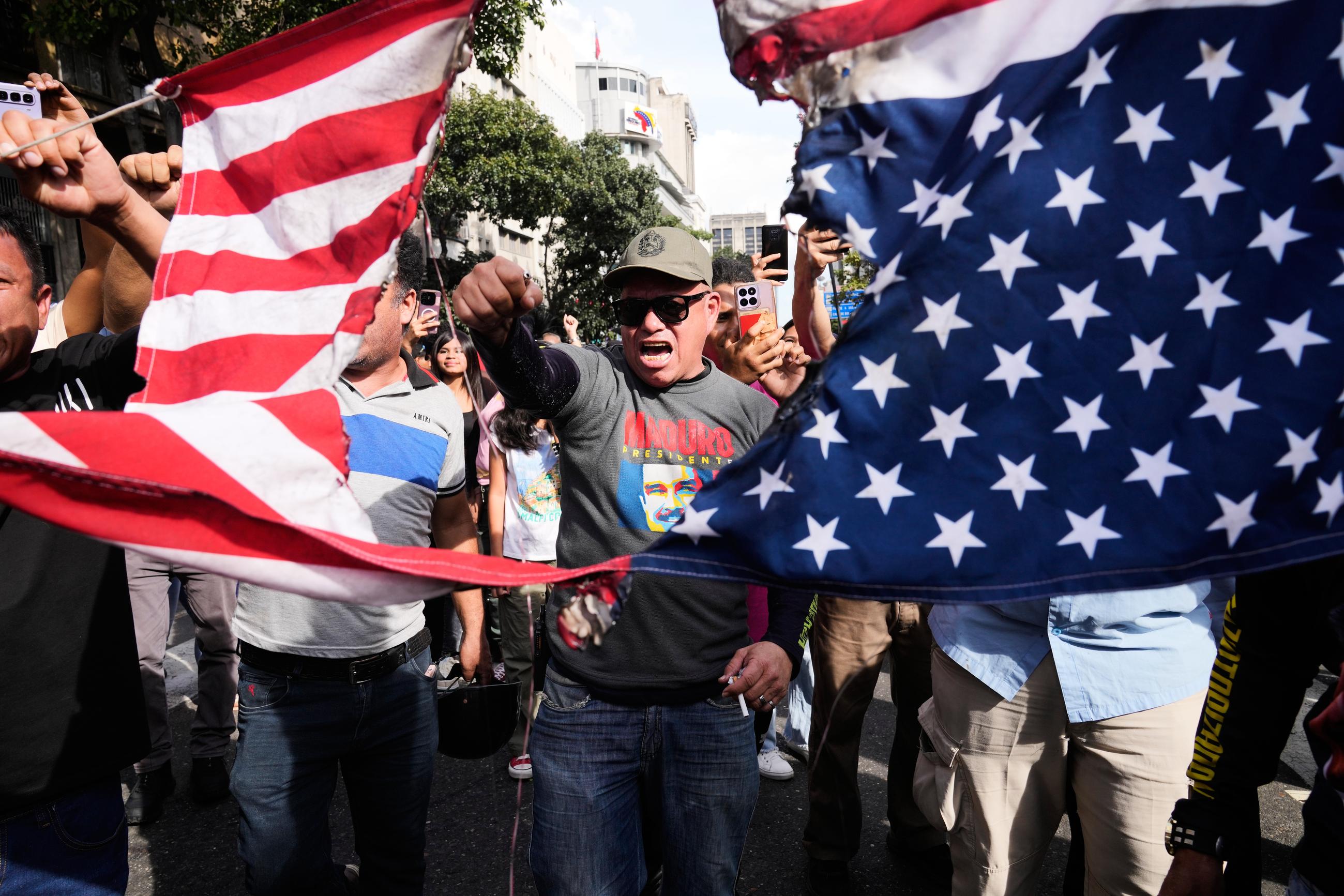 Government supporters rip an American flag in half during a protest in Caracas, Venezuela, on Saturday.