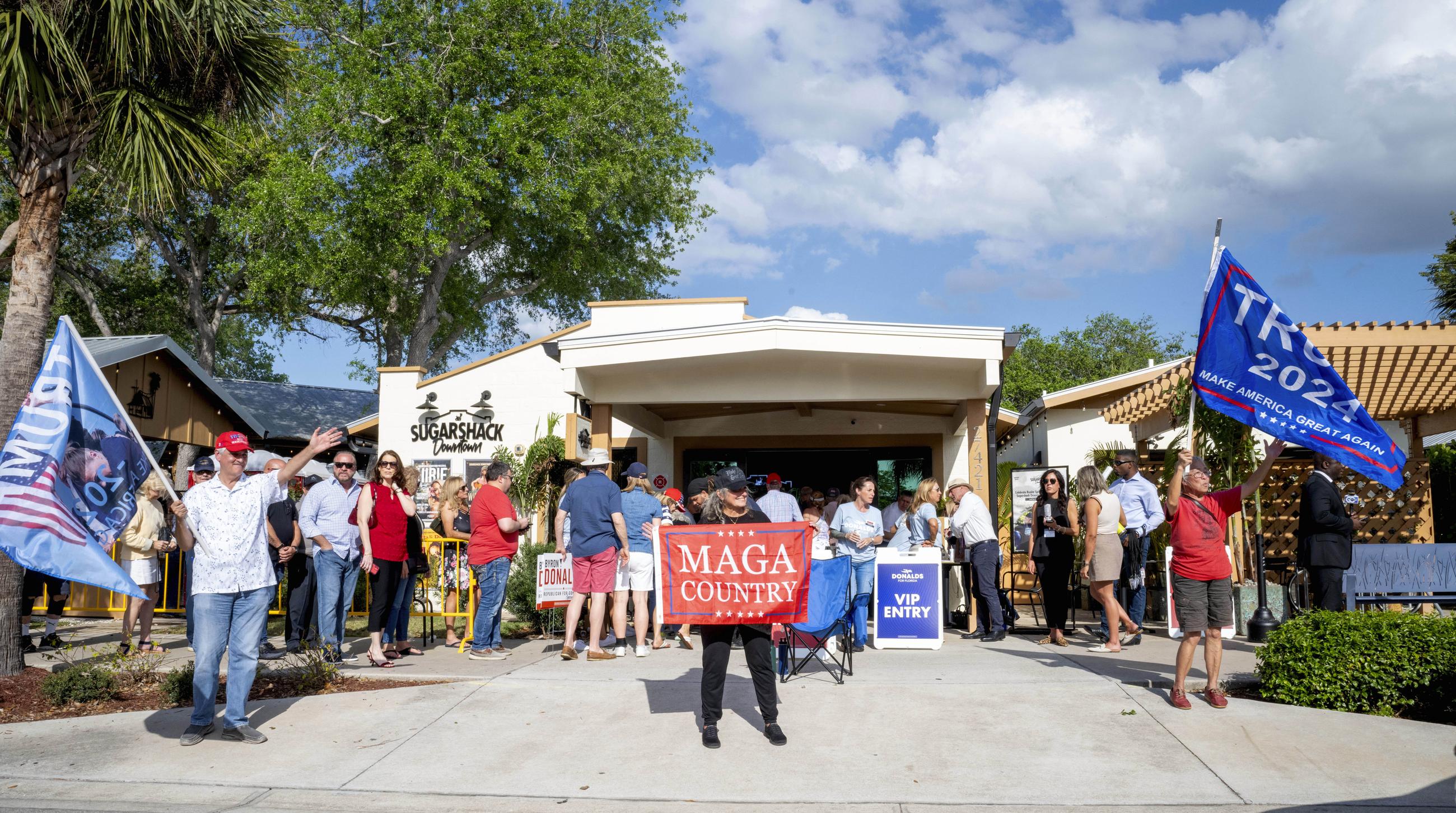 Supporters stand in line and wave flags before the start of the gubernatorial campaign kickoff rally for Rep. Byron Donalds in Bonita Springs, Fla., in March. (AP Photo/Chris Tilley)