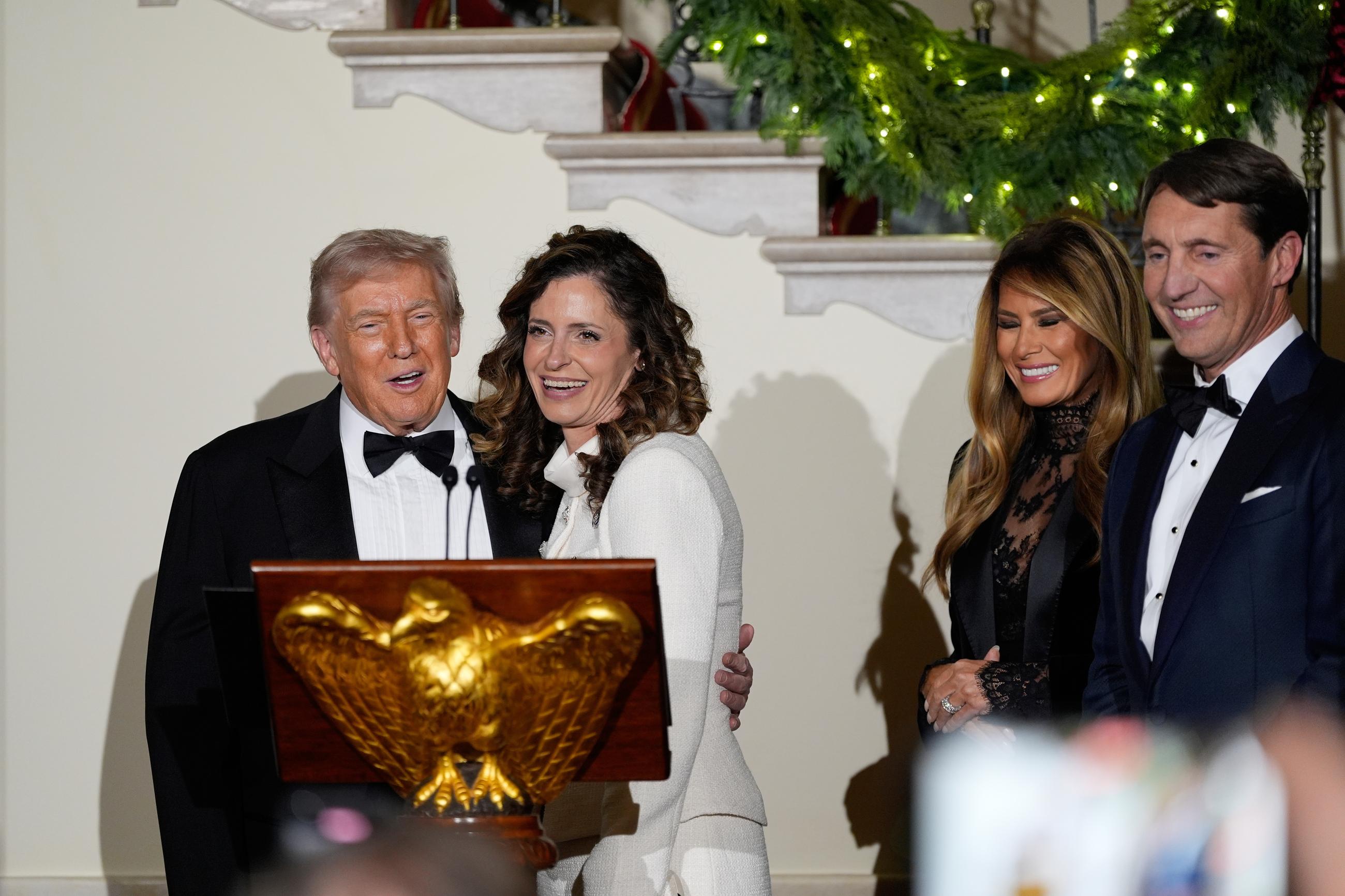 Accompanied by first lady Melania Trump, President Donald Trump stands at the podium with Rep. Julia Letlow R-La., as he speaks in the Grand Foyer of the White House during the Congressional Ball, Thursday, Dec. 11, 2025, in Washington. (AP Photo/Alex Brandon)