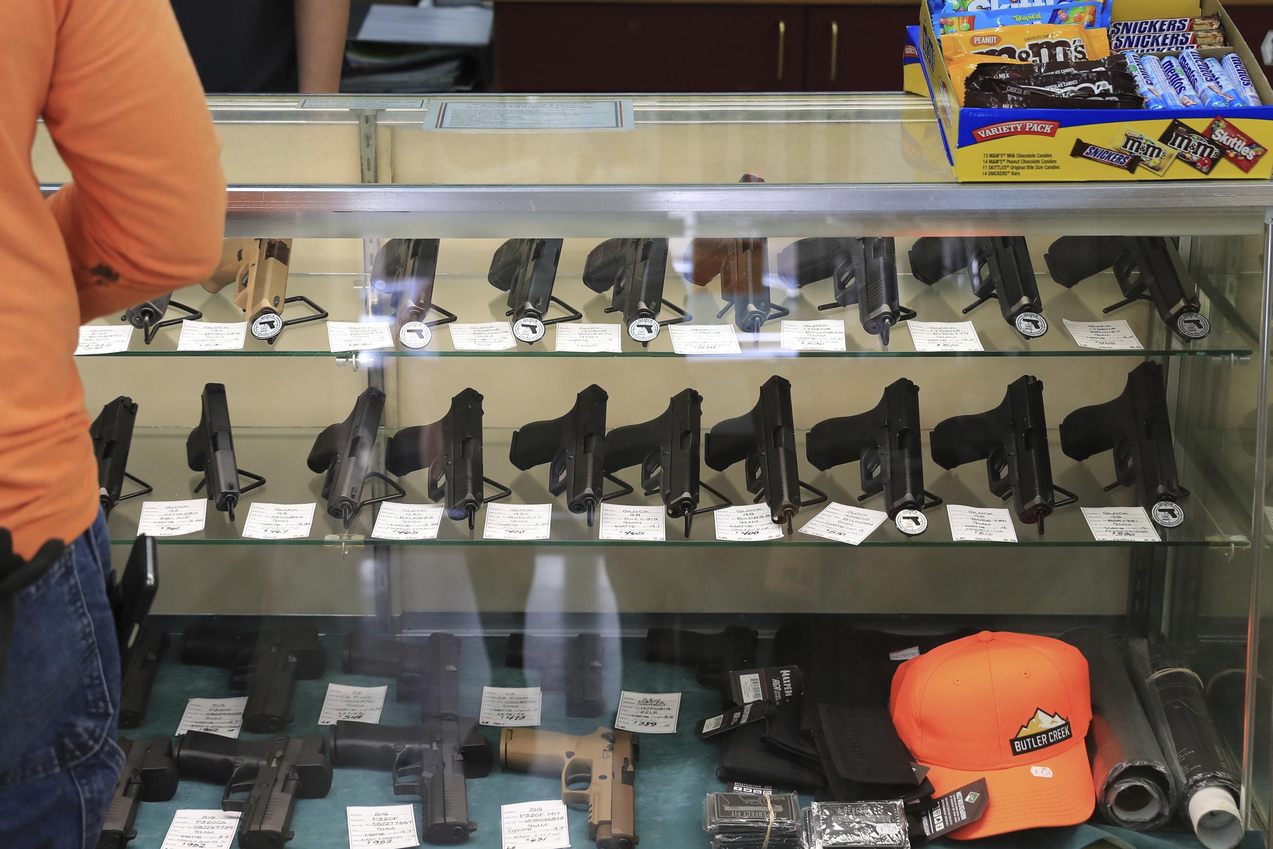 FILE - Handguns are displayed at a gun shop on June, 23, 2022, in Honolulu. Three Hawaii residents challenging the state's new law prohibiting where people can carry concealed firearms argue in a lawsuit that they should be able to take their guns to the beach. ginning Saturday, JUly 1, 2023, a new law prohibits carrying a firearm on the sand — and in other places, including banks, bars and restaurants that serve alcohol. (AP Photo/Marco Garcia, File)
