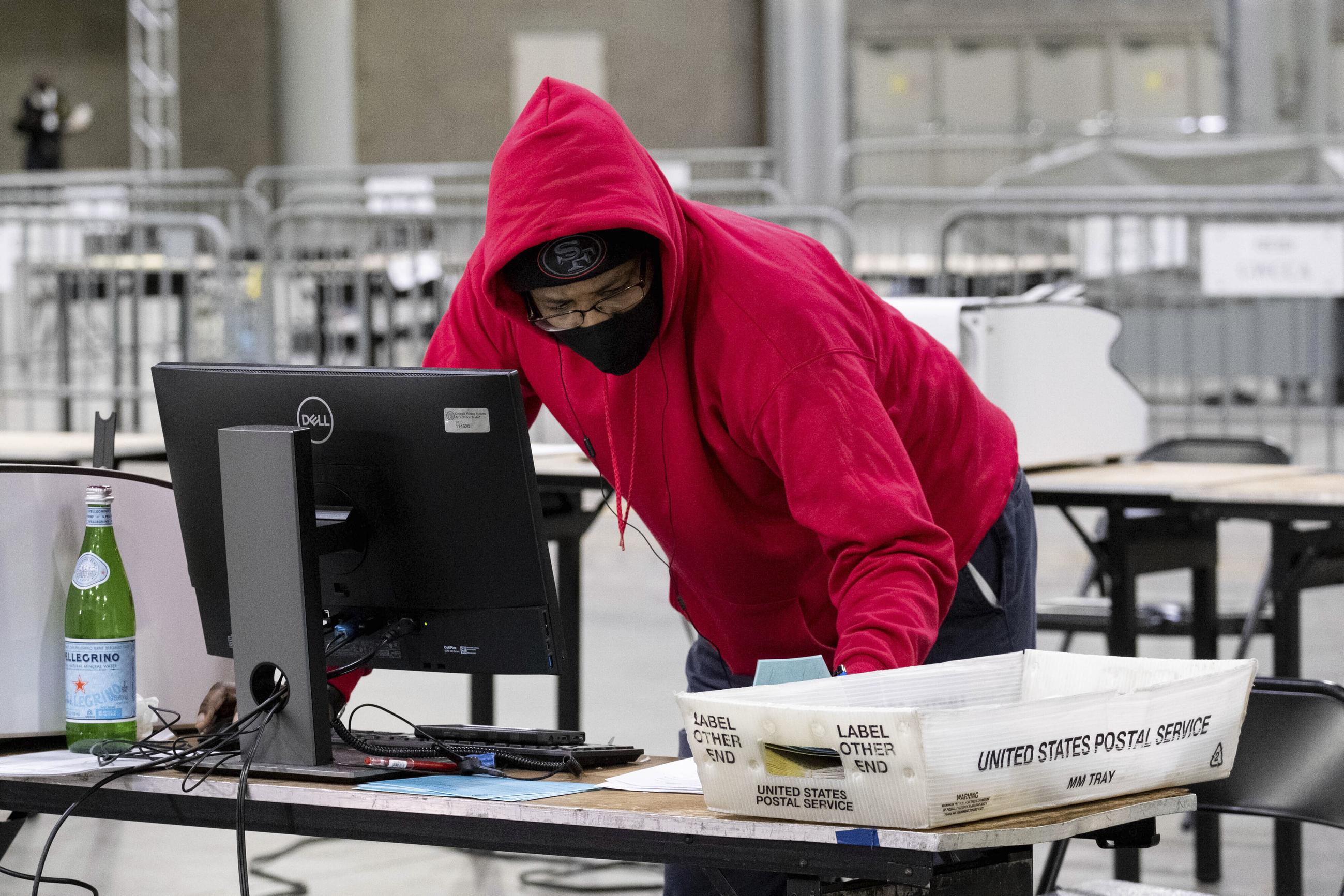 Fulton County Georgia elections workers process absentee ballots for the Senate runoff election in Atlanta on Tuesday, Jan. 5, 2021. Georgia's two Senate runoff elections on Tuesday will determine which party controls the U.S. Senate. Republican Kelly Loeffler is going up against Democrat Raphael Warnock, while Republican David Perdue is challenging Democrat Jon Ossoff. Democrats must win both seats to take control of the Senate. (AP Photo/Ben Gray)