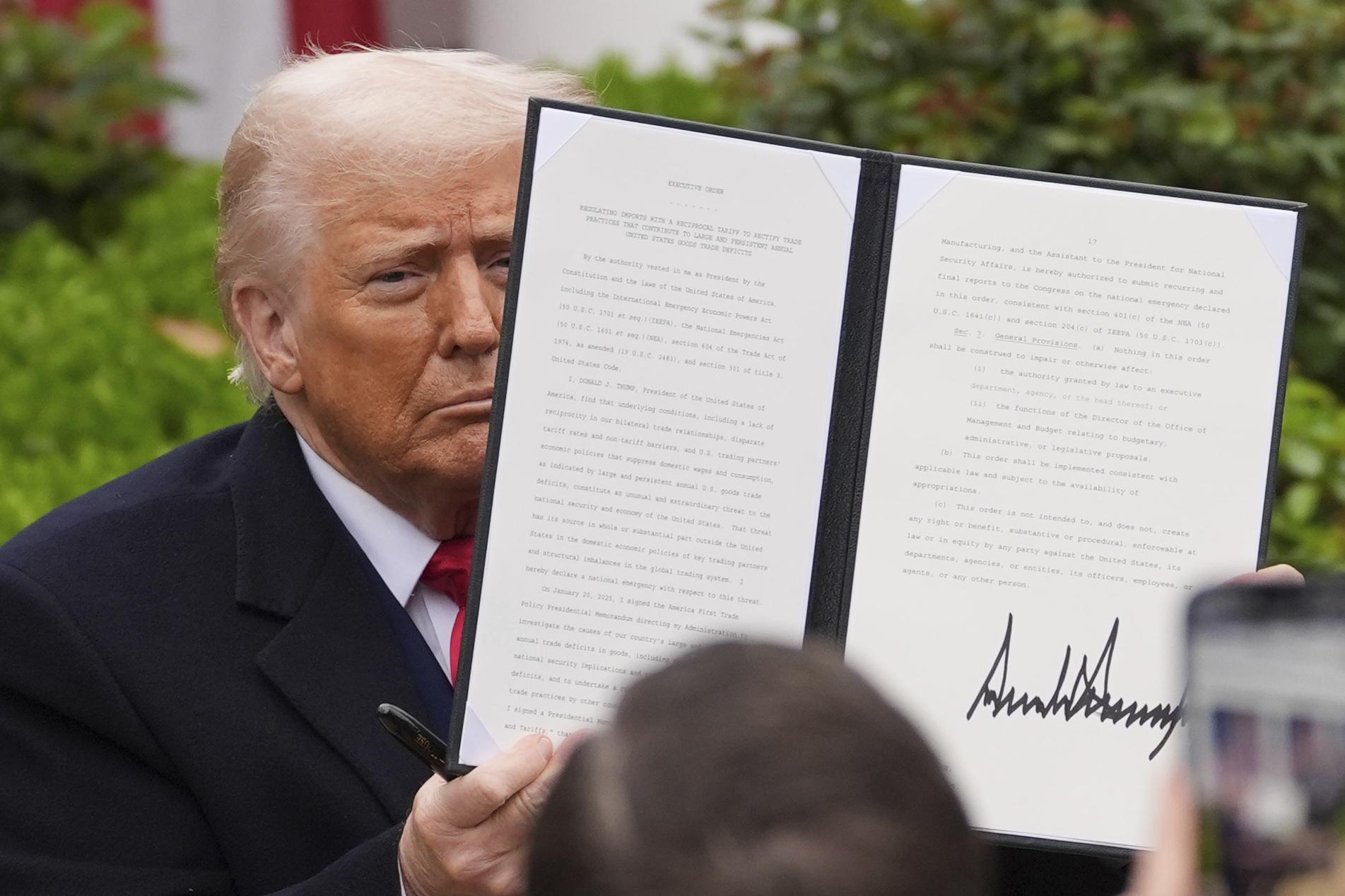 President Trump holds a signed executive order during an event in the Rose Garden to announce new tariffs on April 2, 2025. (AP Photo/Evan Vucci)