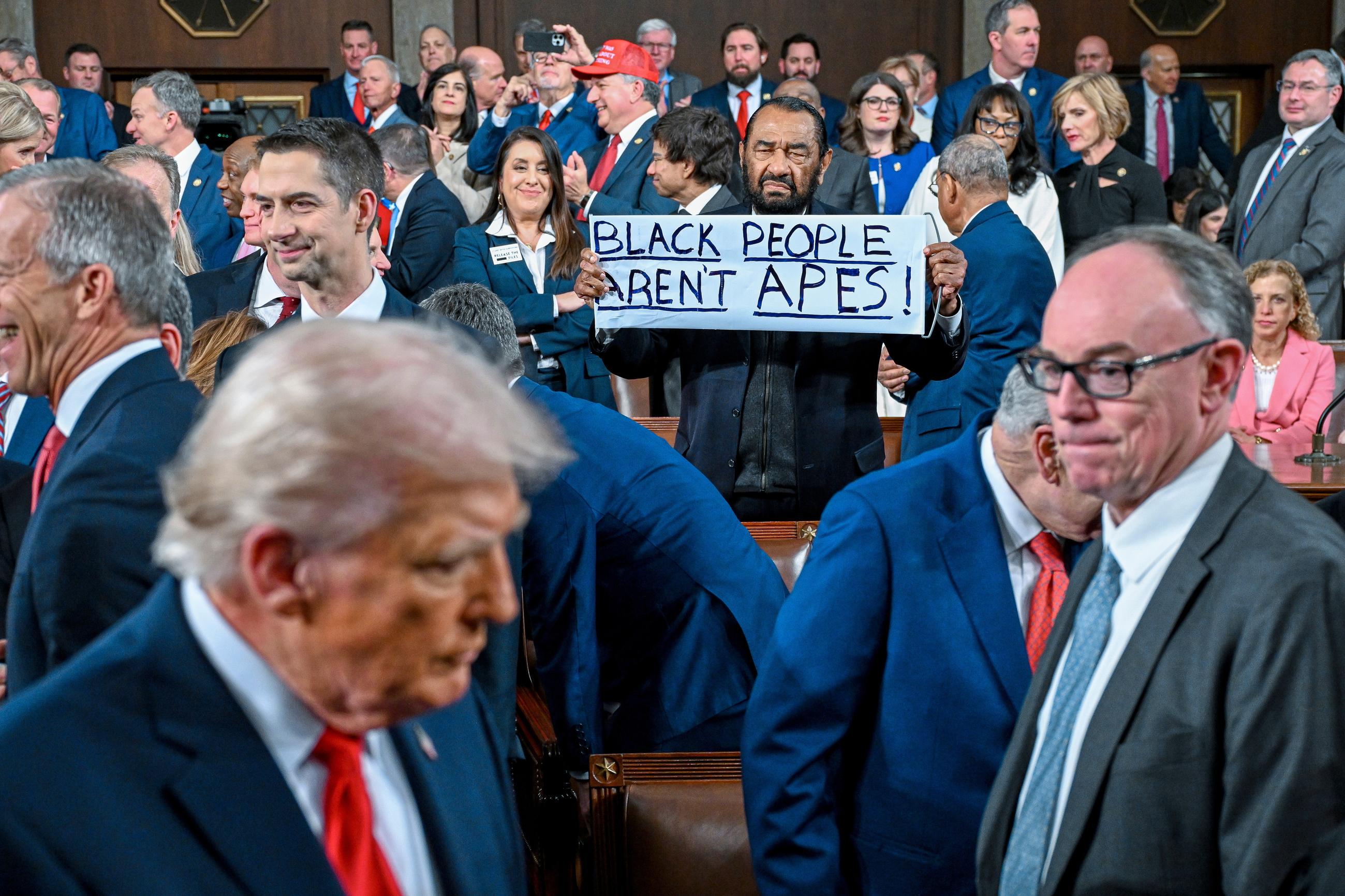 Rep. Al Green holds up a sign as President Trump walks by on his way to deliver the State of the Union address to a joint session of Congress on Tuesday. (Kenny Holston/The New York Times via AP, Pool)