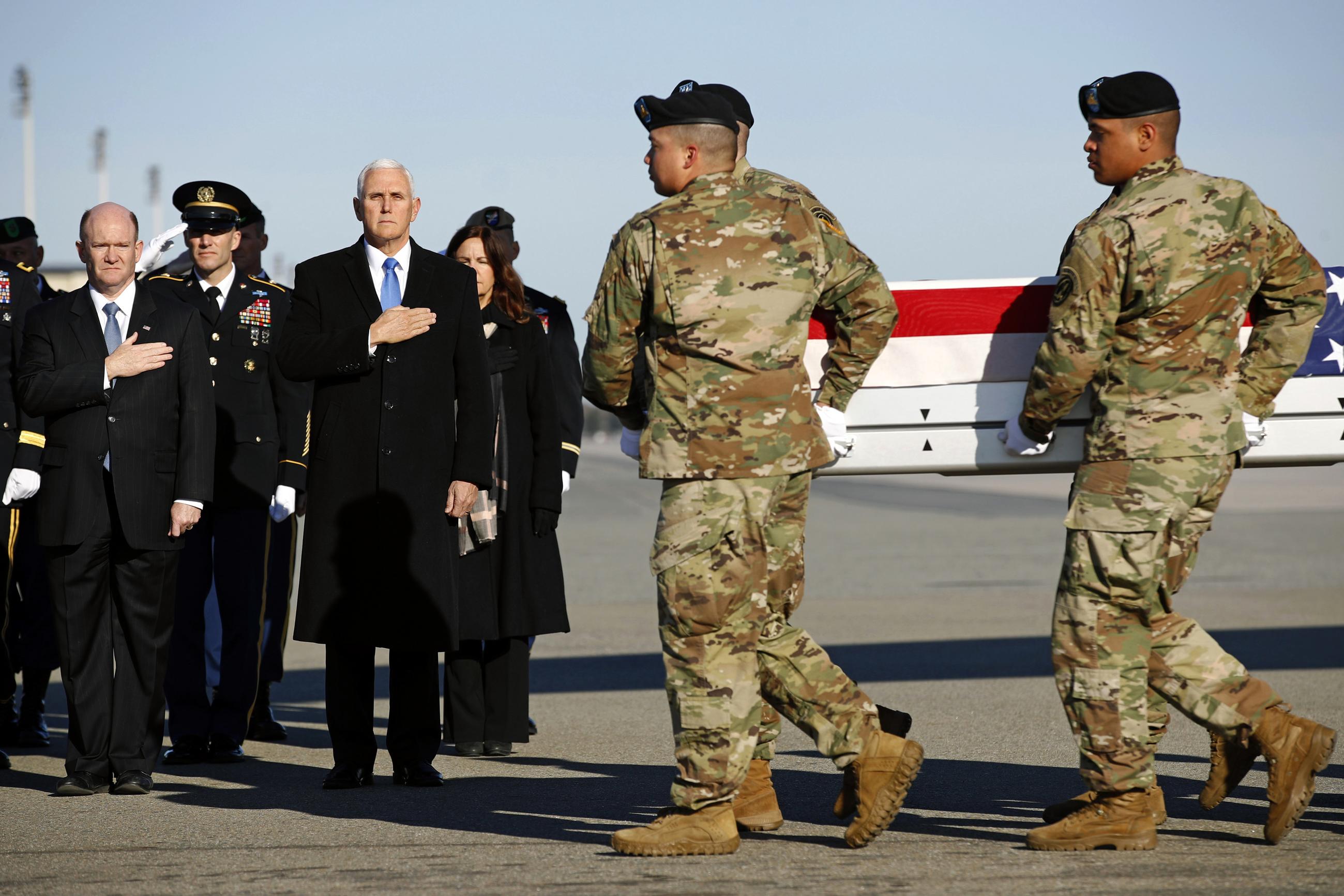 In a photo from March 2019, Sen. Chris Coons, Vice President Mike Pence, and members of an official party stand at attention as a U.S. Army carry team moves a transfer case containing the remains of Spc. Joseph P. Collette at Dover Air Force Base, Del. According to the Department of Defense, Collette was killed while involved in combat operations in Kunduz Province, Afghanistan. (AP Photo/Patrick Semansky)