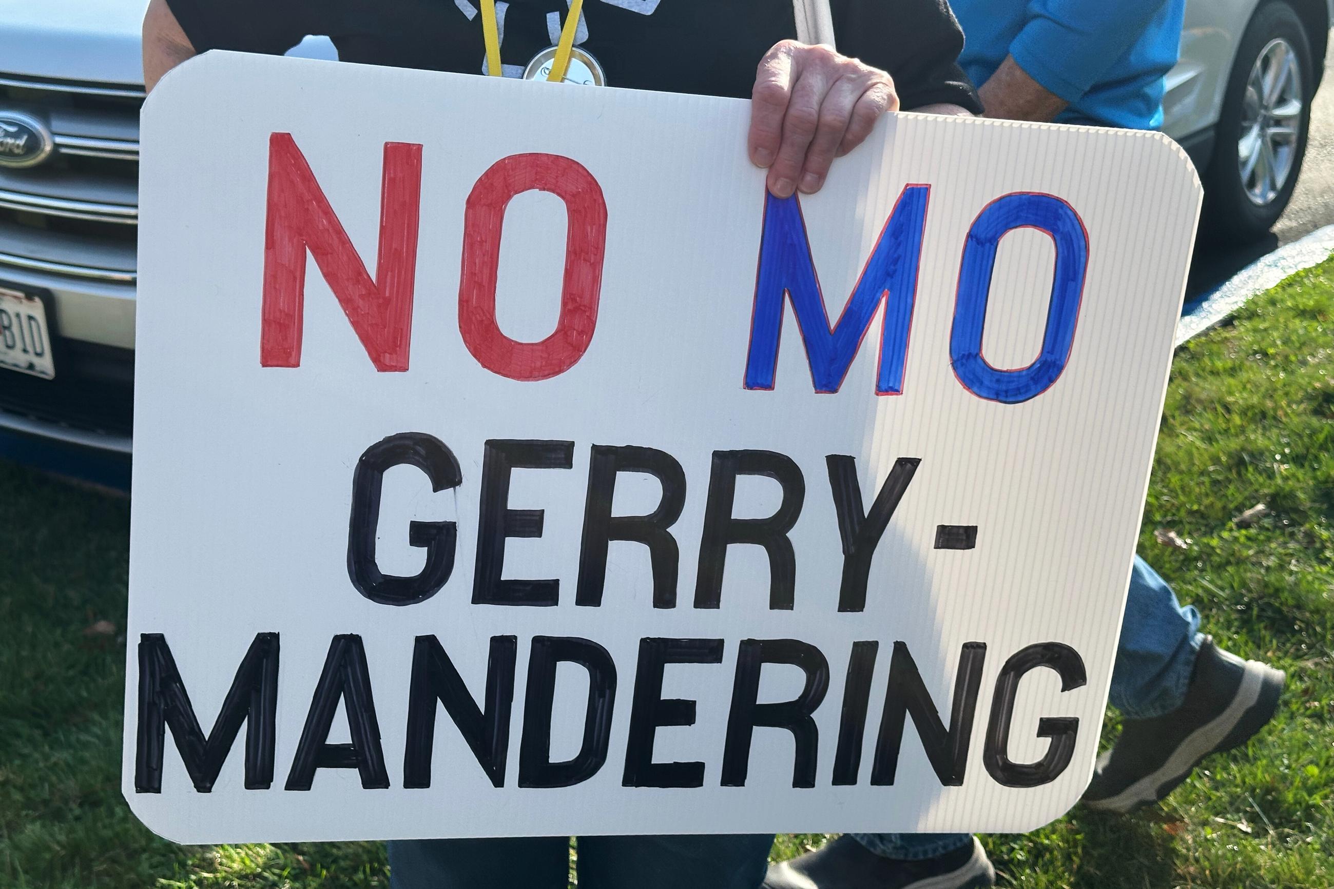 A demonstrator holds a sign opposing the new U.S. House districts passed by the Missouri General Assembly outside the state Capitol in Jefferson City on March 10. (AP Photo/David A. Lieb)