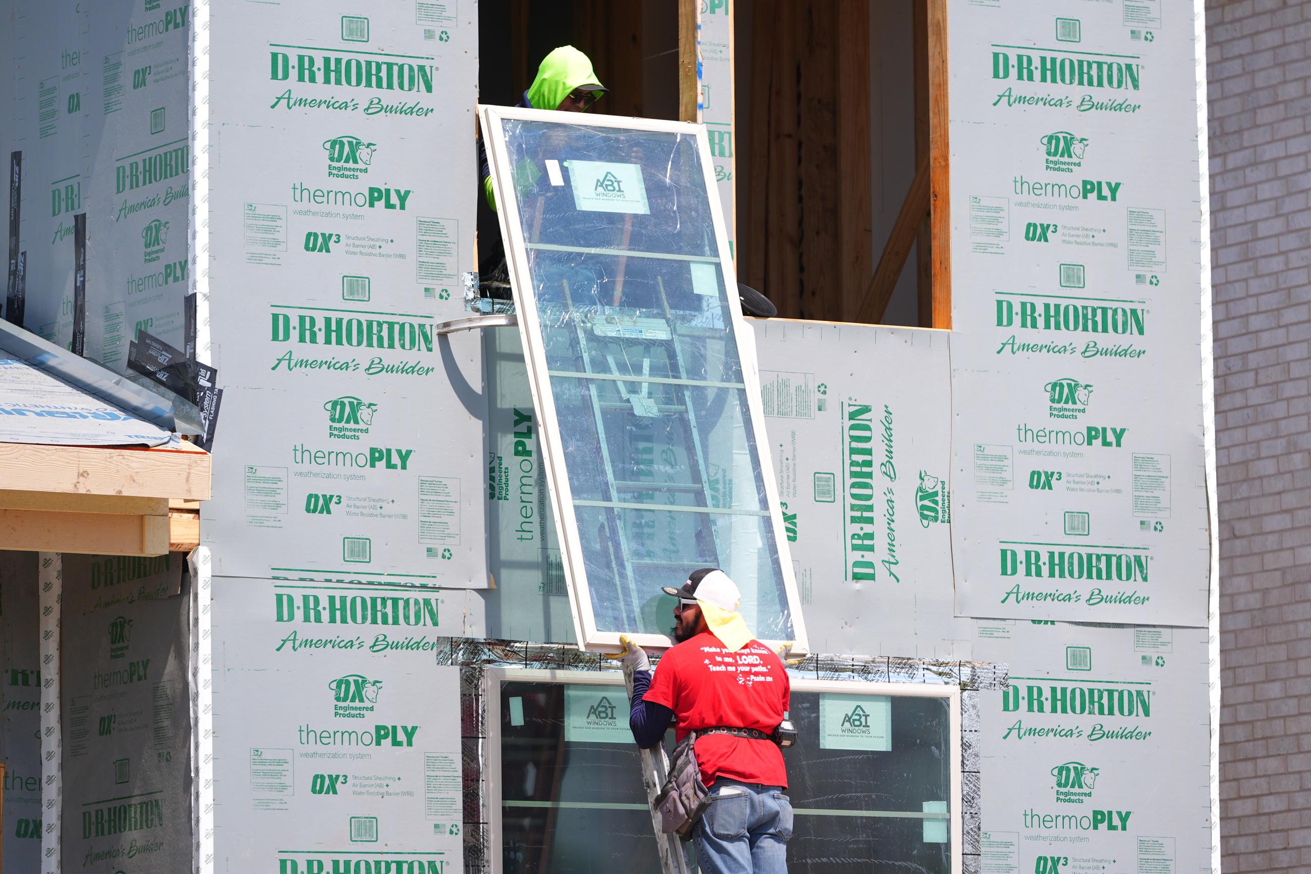 Workers install a window on a house under construction in Richardson, Texas, on March 23. (AP Photo/LM Otero)