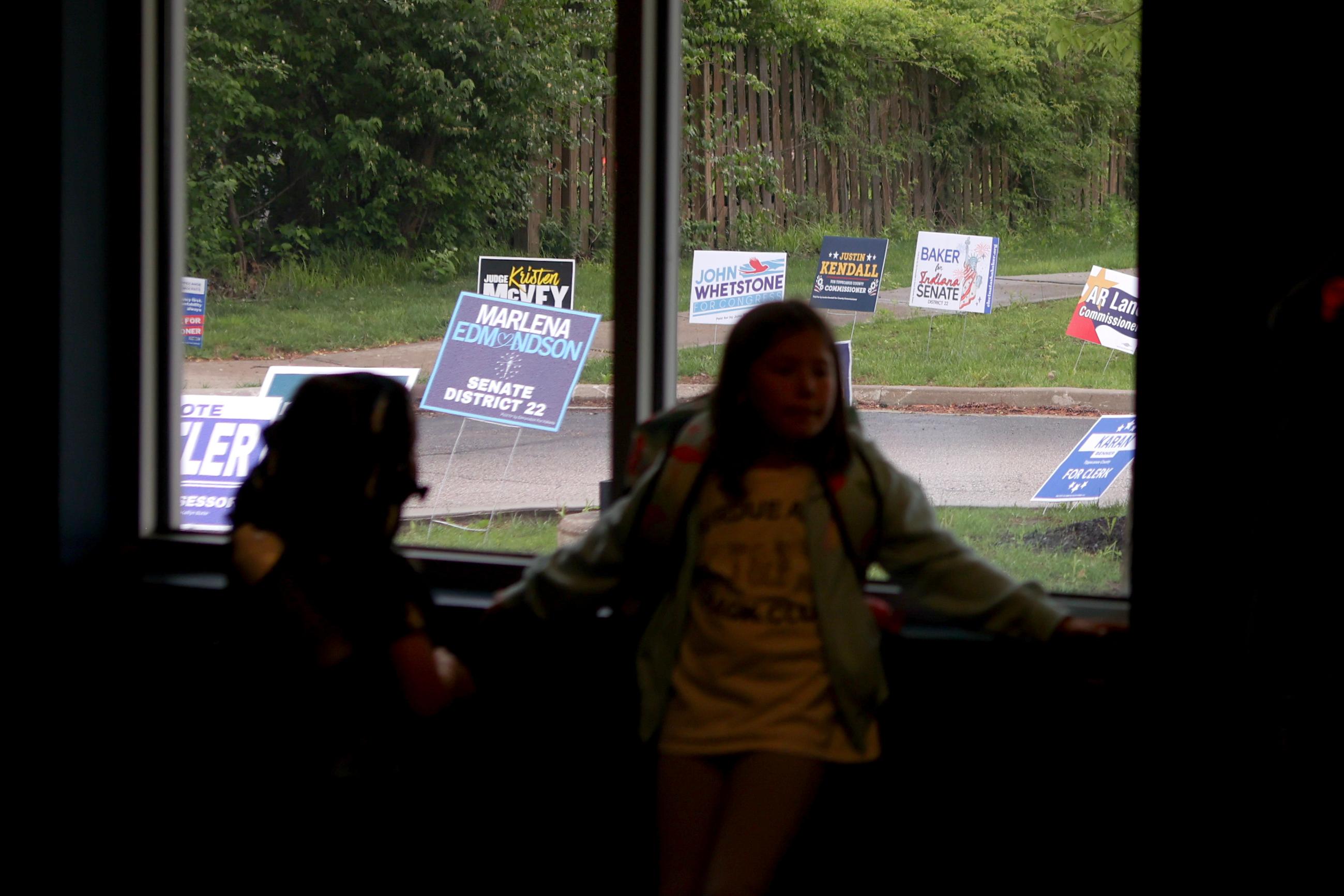 Kids lean against a window in a vote center during a primary election on Tuesday, May 5, 2026, in West Lafayette, Ind. (AP Photo/Cara Penquite)
