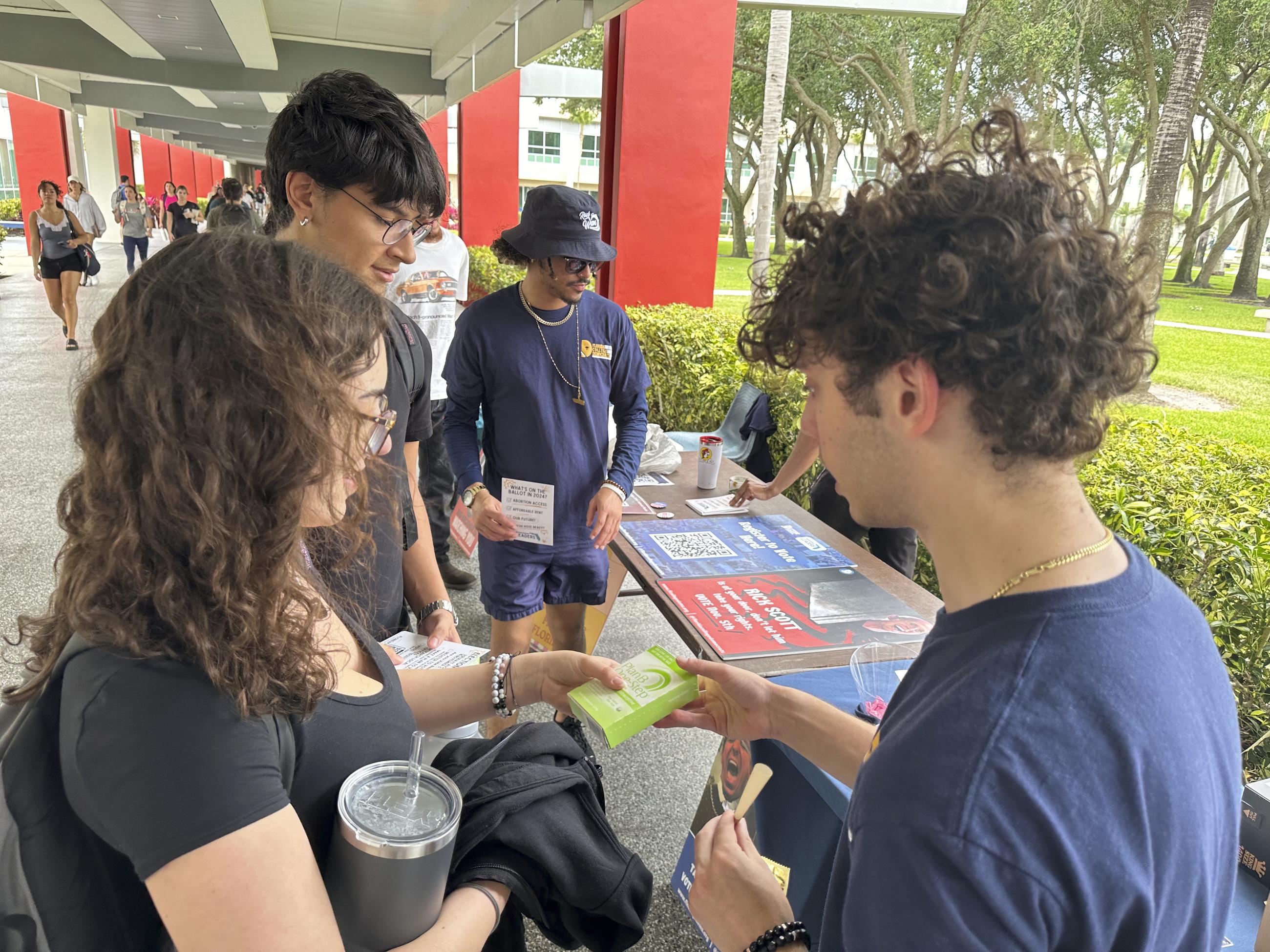 FILE - College students pass out Plan B to educate young voters at Florida Atlantic University in Boca Raton in 2024. (AP Photo/Cody Jackson, File)