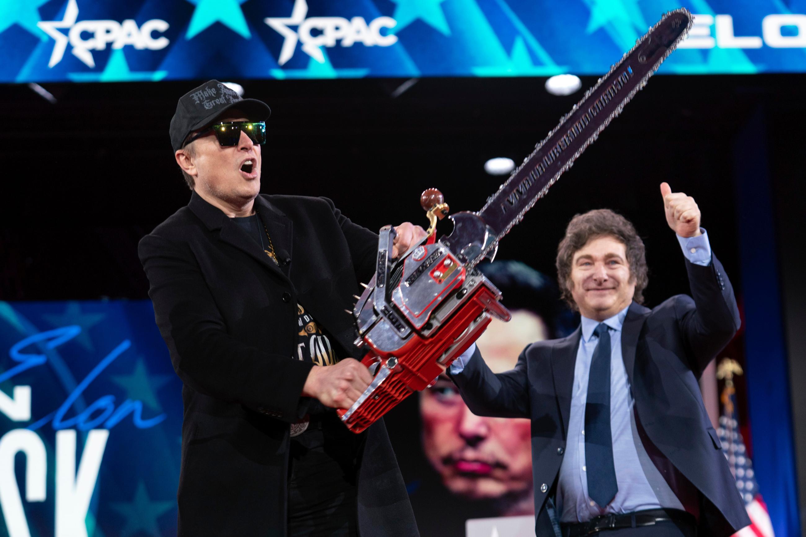 Elon Musk holds up a chainsaw he received from Argentina's President Javier Milei at the Conservative Political Action Conference in Oxon Hill, Md., in February 2025. (AP Photo/Jose Luis Magana, File)