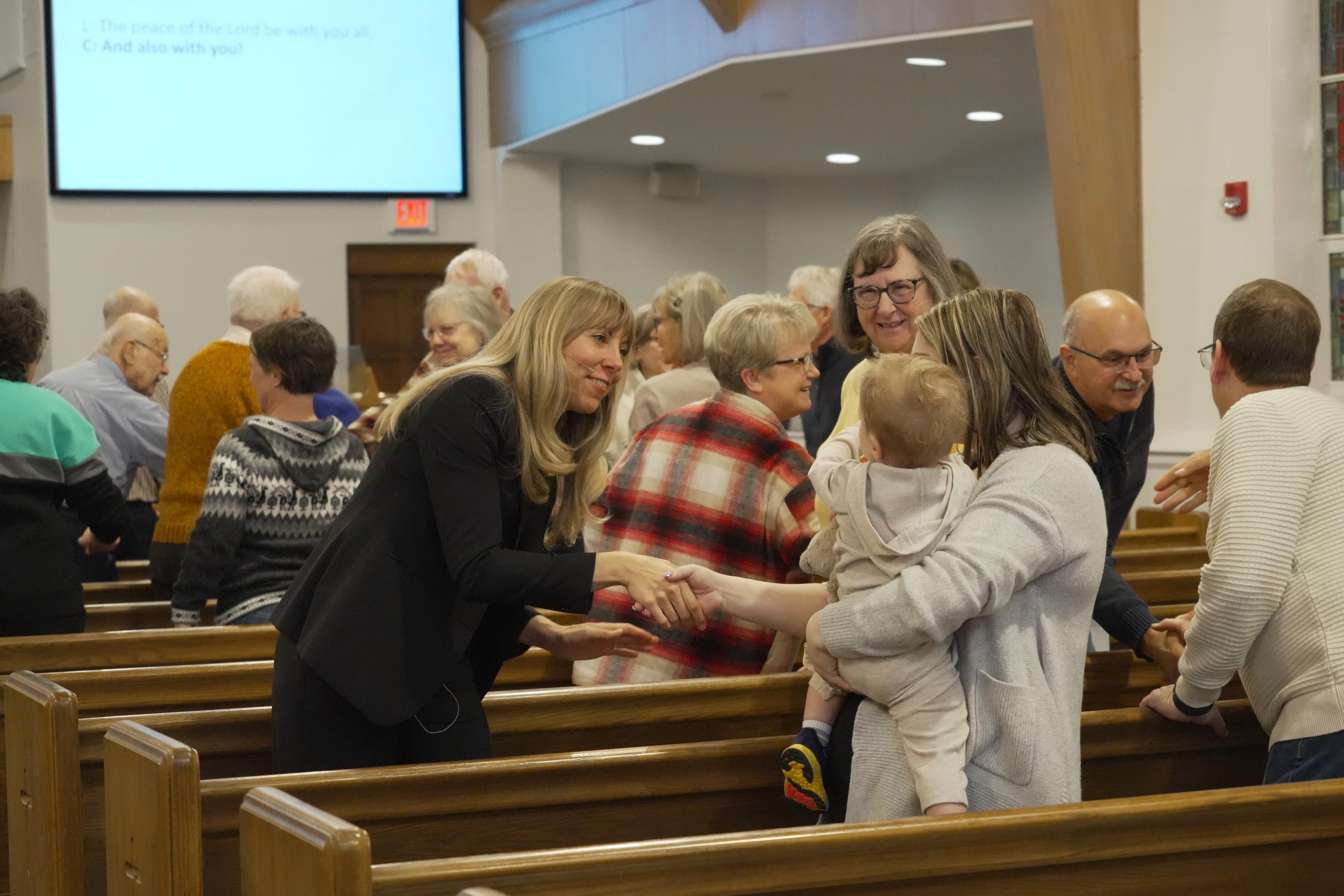 Rev. Sarah Trone Garriott, a Lutheran pastor and Iowa state senator, shakes hands with a congregant at Grace Lutheran Church in Des Moines, Iowa on Sunday, March 15, 2026. (AP Photo/Krysta Fauria)