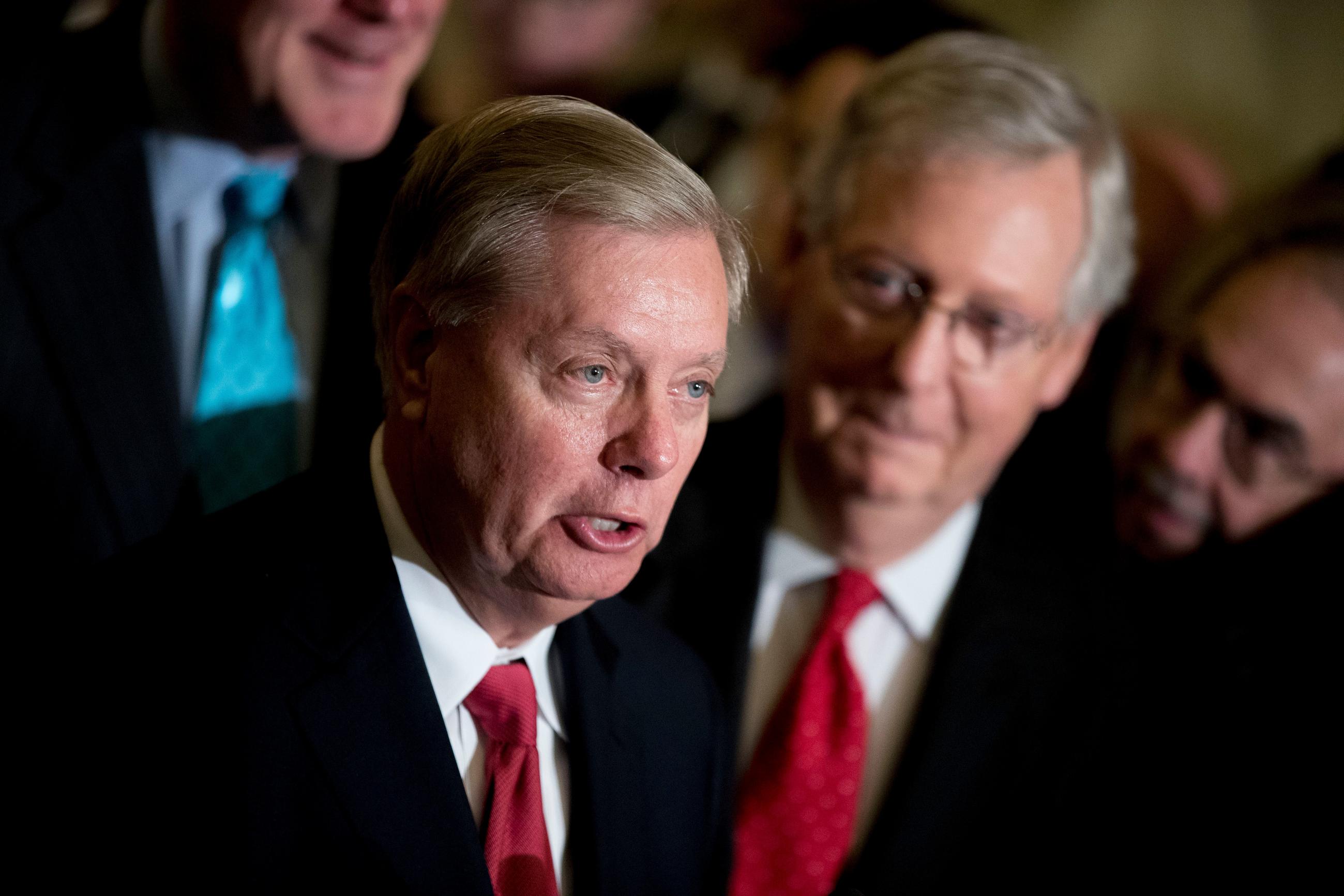 FILE - Sen. Lindsey Graham, R-S.C., flanked by Senate Majority Leader Mitch McConnell, R-Ky., right, speaks to reporters at the Capitol in Washington, Sept. 26, 2017. (AP Photo/Andrew Harnik, File)
