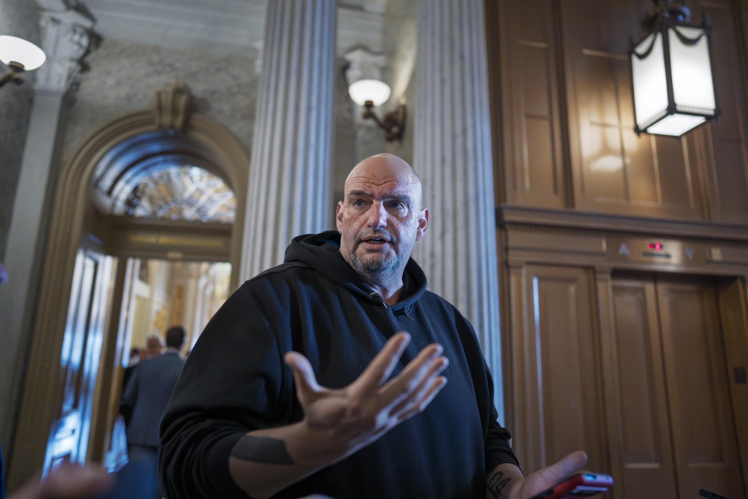 Sen. John Fetterman, D-Pa., talks to reporters outside the chamber during a vote, at the Capitol in Washington, Thursday, March 13, 2025. (AP Photo/J. Scott Applewhite)