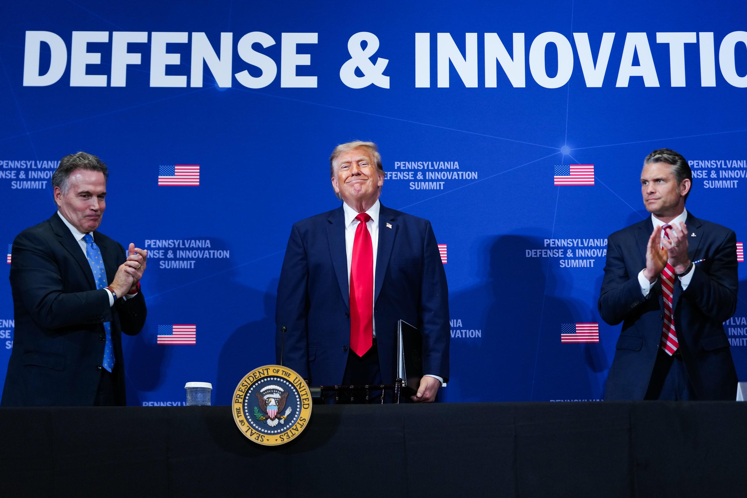 Sen. Dave McCormick, R-Pa., left, and Defense Secretary Pete Hegseth, right, applaud as President Donald Trump, center, stands to depart after speaking at a roundtable during the Pennsylvania Defense and Innovation Summit, Wednesday, July 15, 2026, at the United States Army War College in Carlisle, Pa. (AP Photo/Julia Demaree Nikhinson)