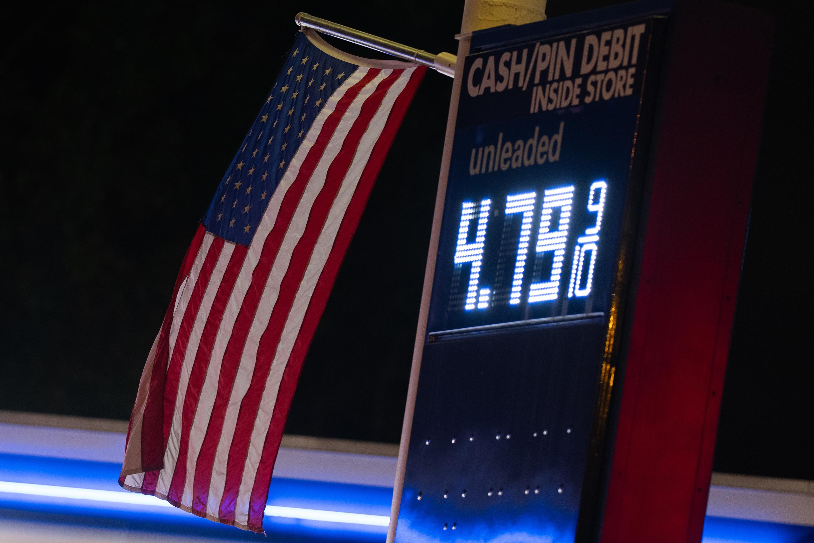 An American flag flies near a sign for fuel prices at a gas station in Portland, Ore., on May 6. (AP Photo/Jenny Kane)