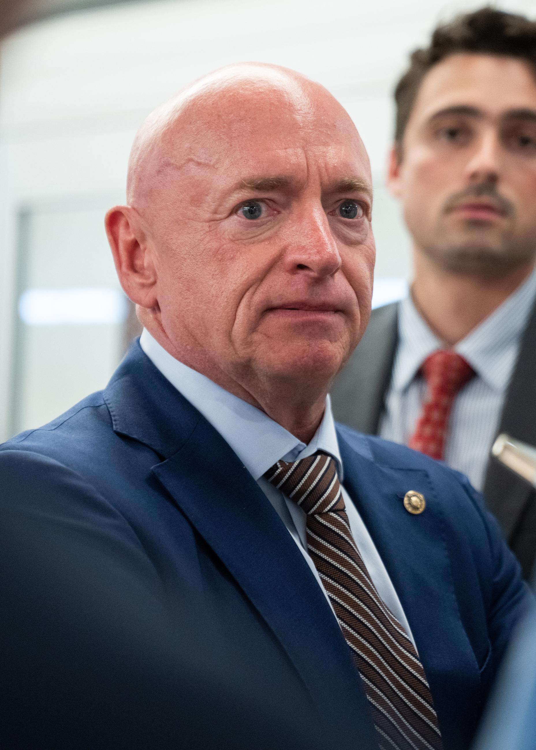 Sen. Mark Kelly, D-Ariz., talks with reporters at the Capitol during votes in Washington, Thursday, July 16, 2026. (AP Photo/Allison Robbert)