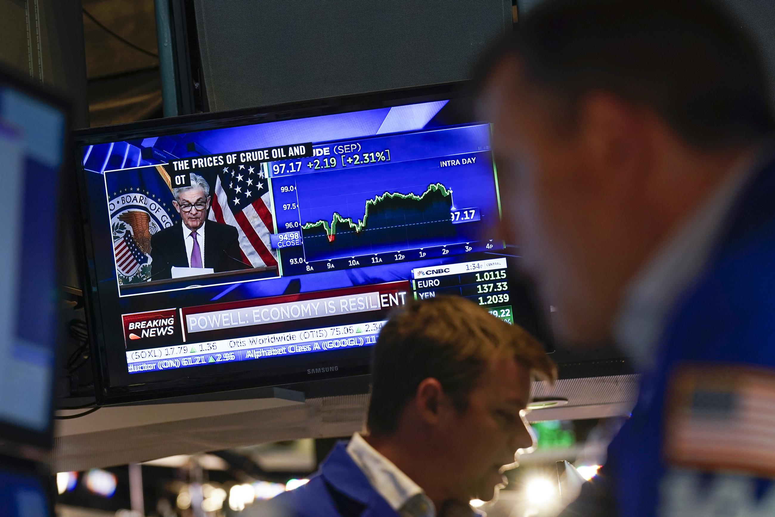 As traders work and watch, a news conference held by Federal Reserve Chair Jerome Powell is displayed at the New York Stock Exchange in New York, Wednesday, July 27, 2022. Stocks on Wall Street are solidly higher in afternoon trading Wednesday after the Federal Reserve raised its key interest rate by a widely expected three-quarters of a point as the central bank ratchets up its campaign to quell surging inflation. (AP Photo/Seth Wenig)