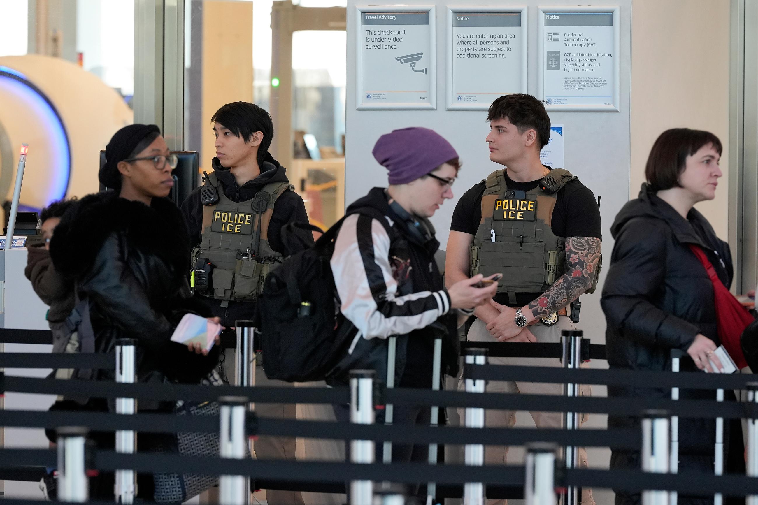 Immigration and Customs Enforcement agents monitor security lines, Tuesday, March 24, 2026, at LaGuardia Airport in New York. (AP Photo/Yuki Iwamura)