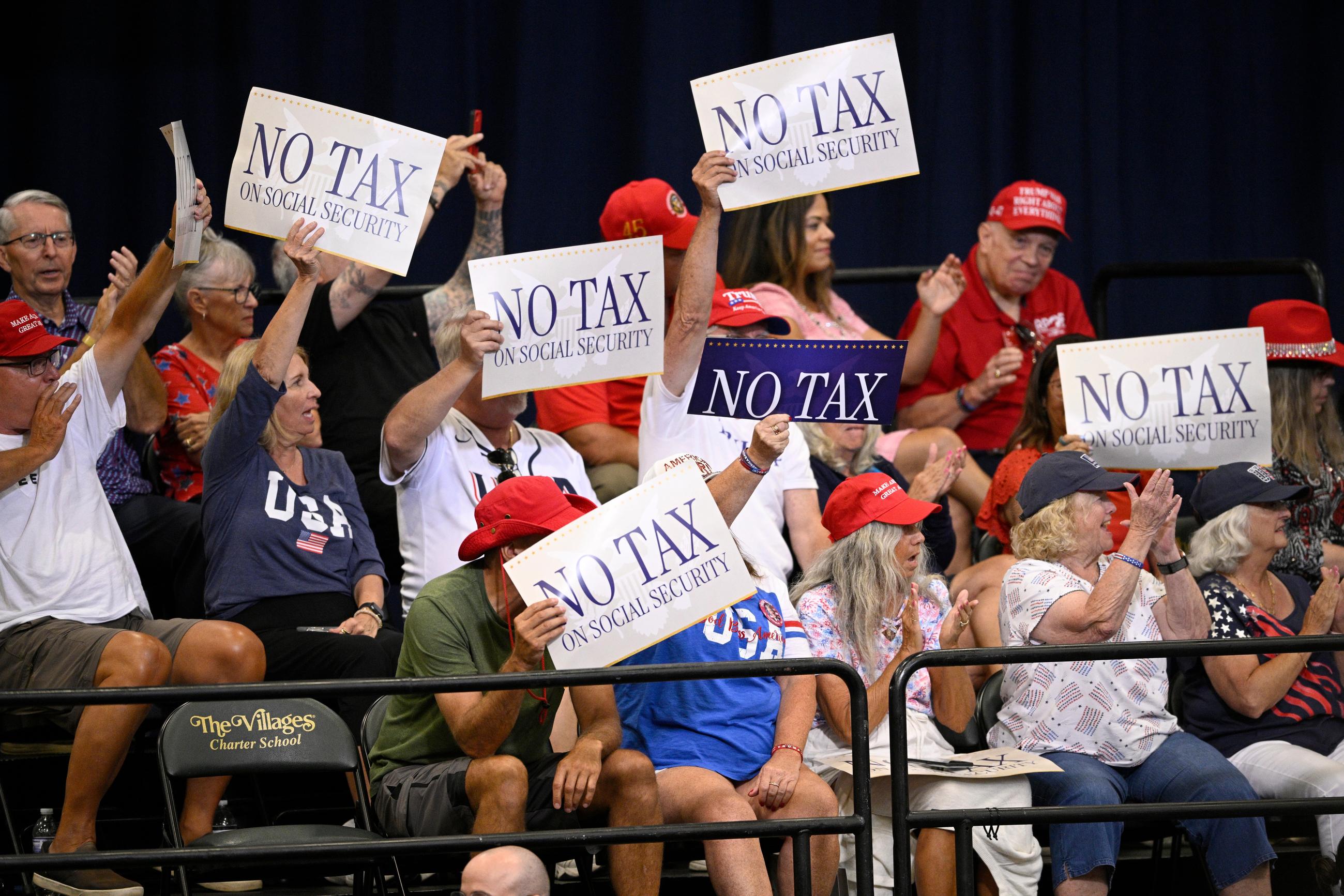 Supporters hold “No Tax on Social Security” signs during a visit by President Donald Trump, Friday, May 1, 2026, in The Villages, Fla. (AP Photo/Phelan M. Ebenhack)