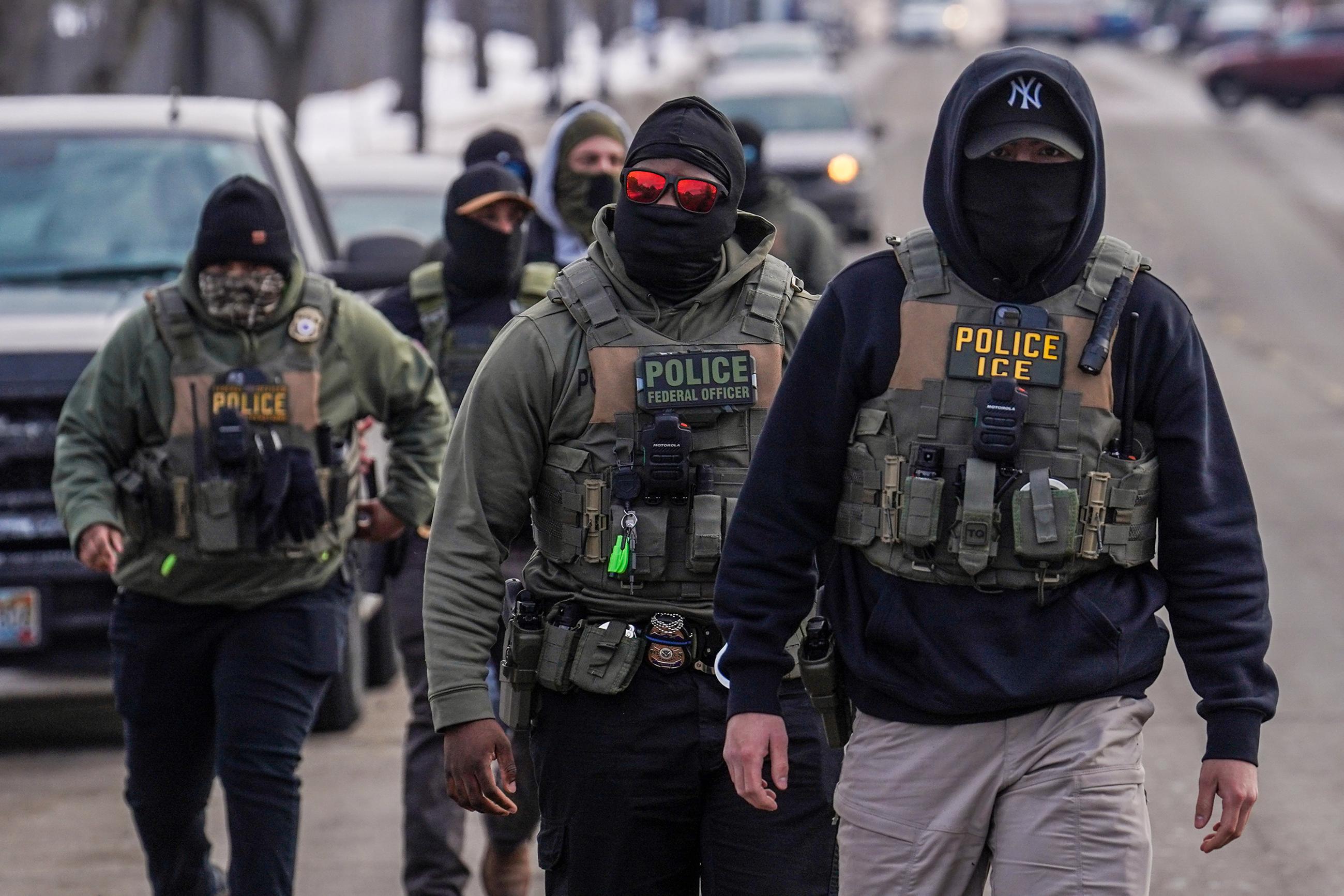 Federal agents walk down a street while conducting immigration enforcement operations in Minneapolis, Feb. 5, 2026. (AP Photo/Ryan Murphy, File)