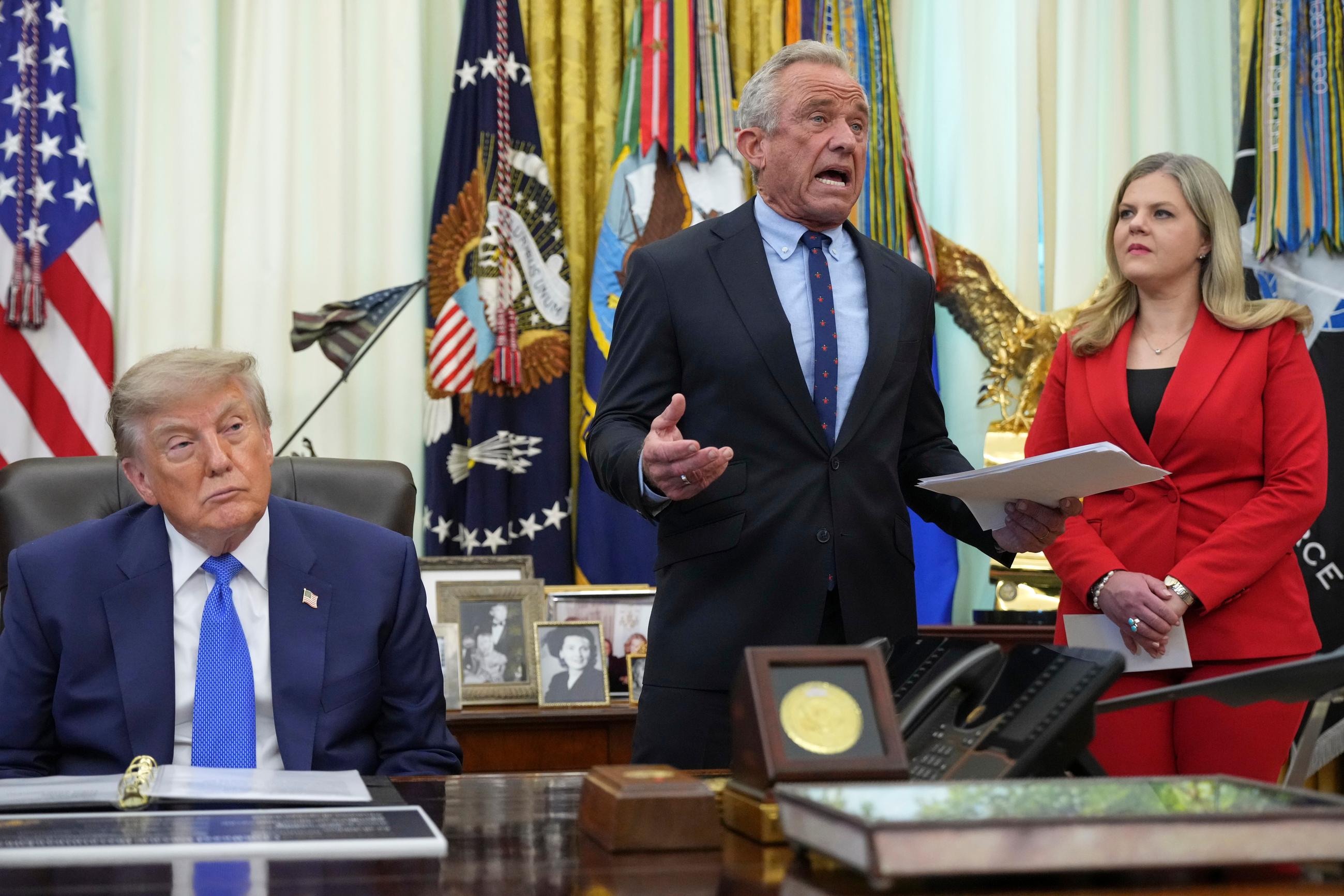 President Trump, with Health and Human Services Secretary Robert F. Kennedy Jr. and White House domestic adviser Heidi Overton, at a meeting in the Oval Office to sign an executive order concerning vaccines on Aug. 10 (AP Photo/Jacquelyn Martin)