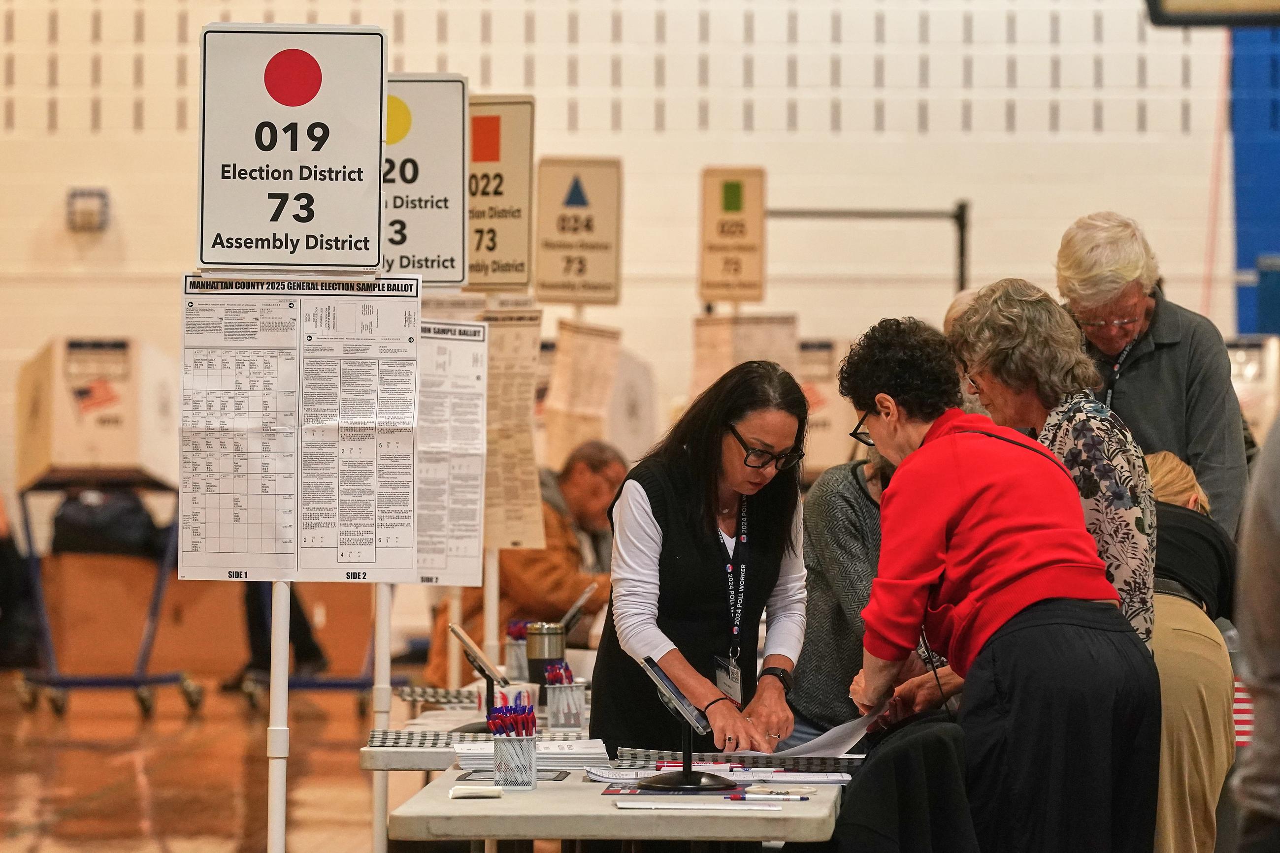 Workers prepare for voters at a polling site in New York on Nov. 4, 2025. (AP Photo/Richard Drew)
