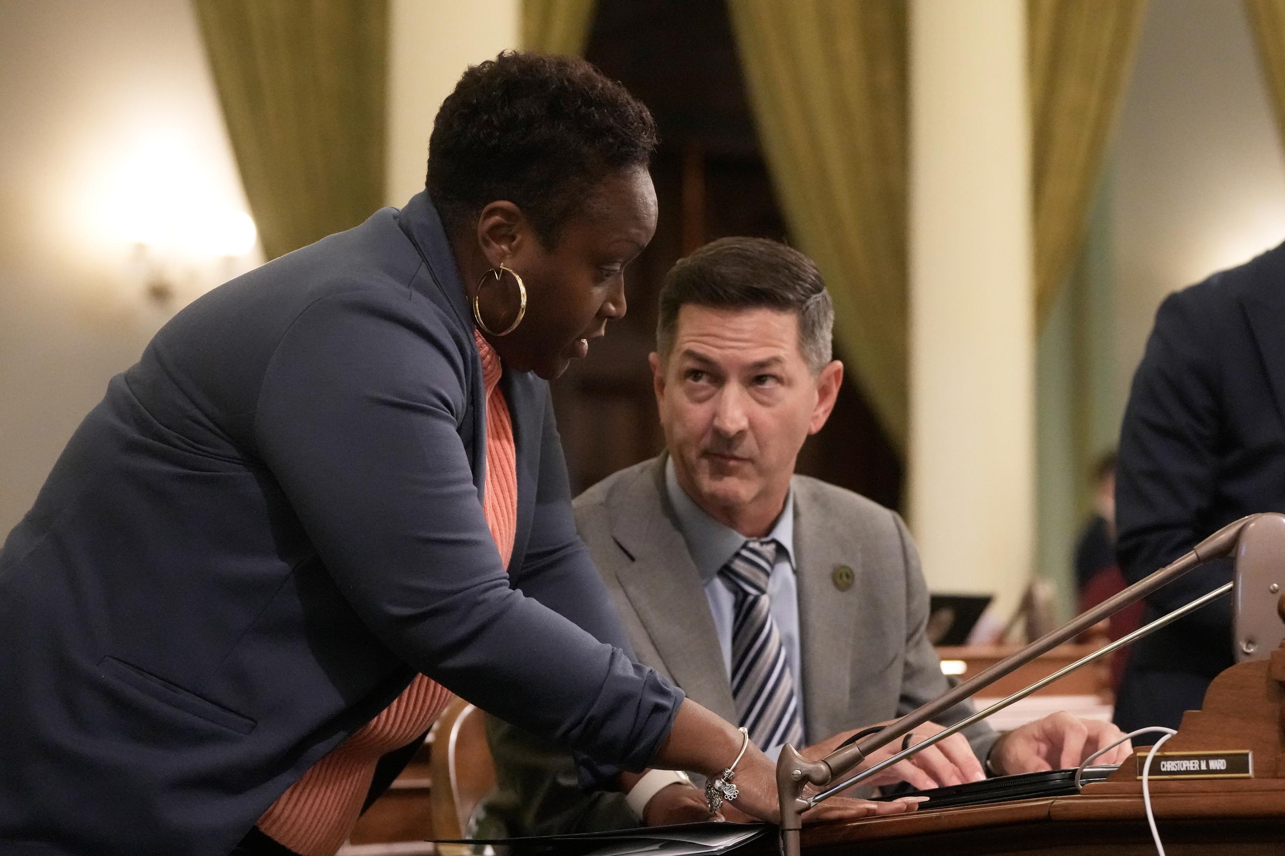 California Assemblymember LaShae Sharp-Collins (left) talks with Assemblymember Christopher Ward at the Capitol in Sacramento on Aug. 31. (AP Photo/Jeff Chiu)