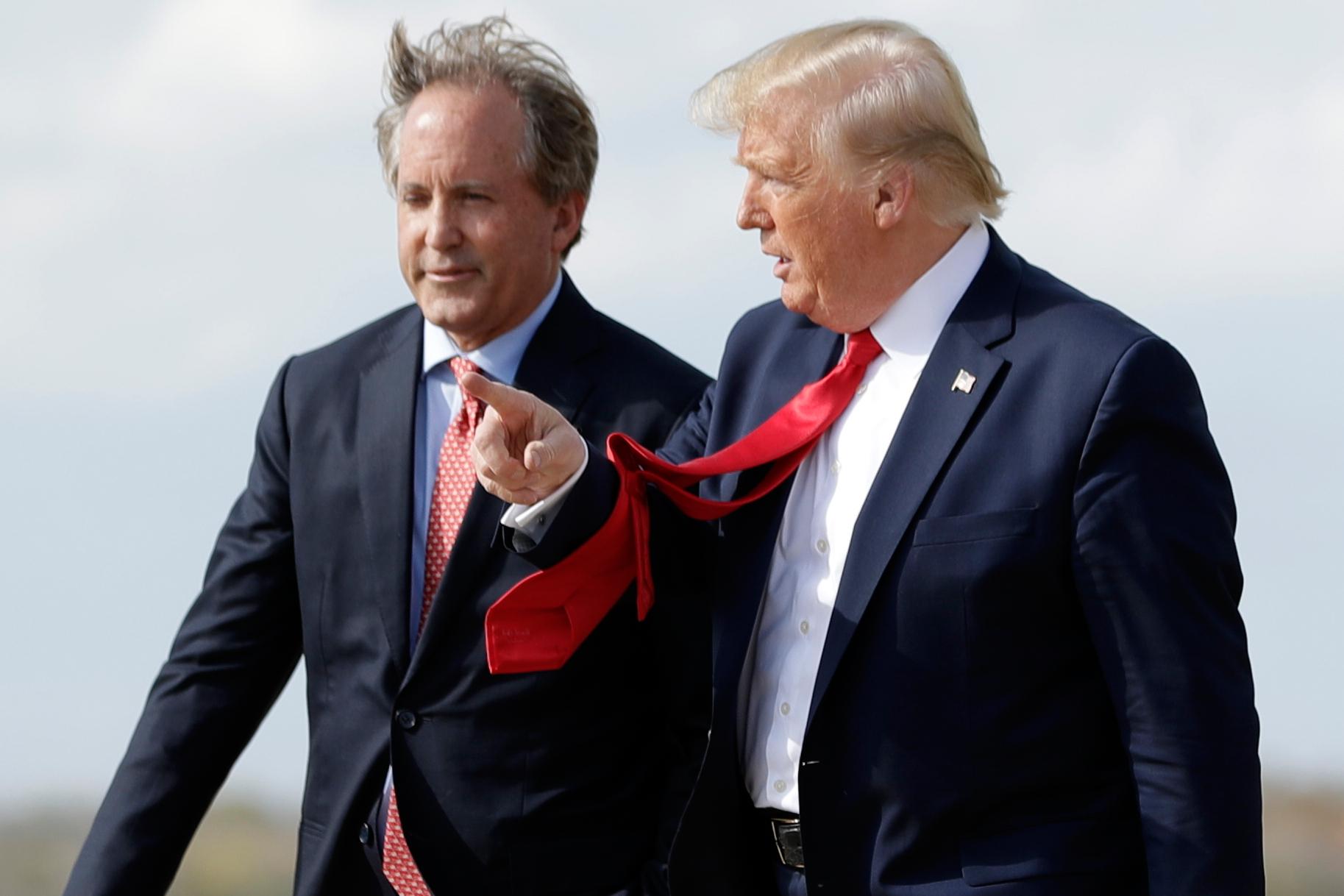FILE - President Donald Trump walks with Texas Attorney General Ken Paxton, left, at Austin-Bergstrom International Airport in Austin, on Wednesday, Nov. 20, 2019. (AP Photo/Evan Vucci, File)