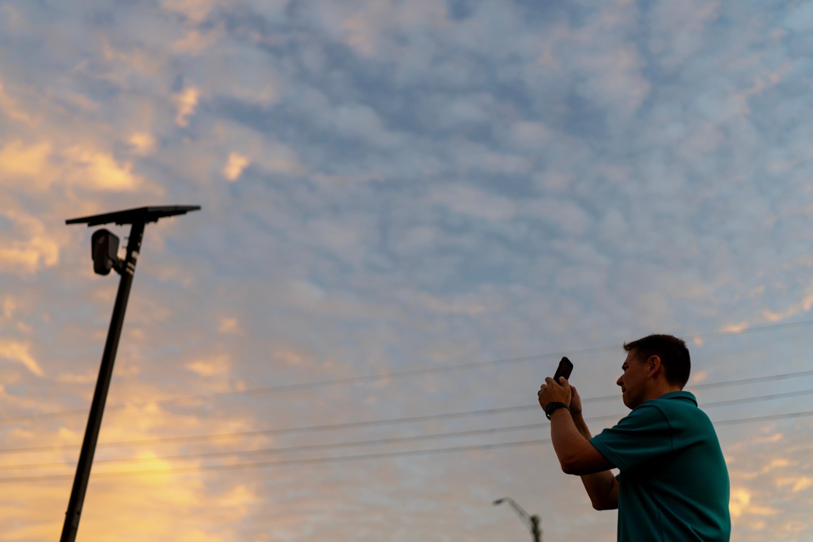 A man photographs a Flock Safety license-plate reader in his Houston neighborhood in 2025. (AP Photo/David Goldman)