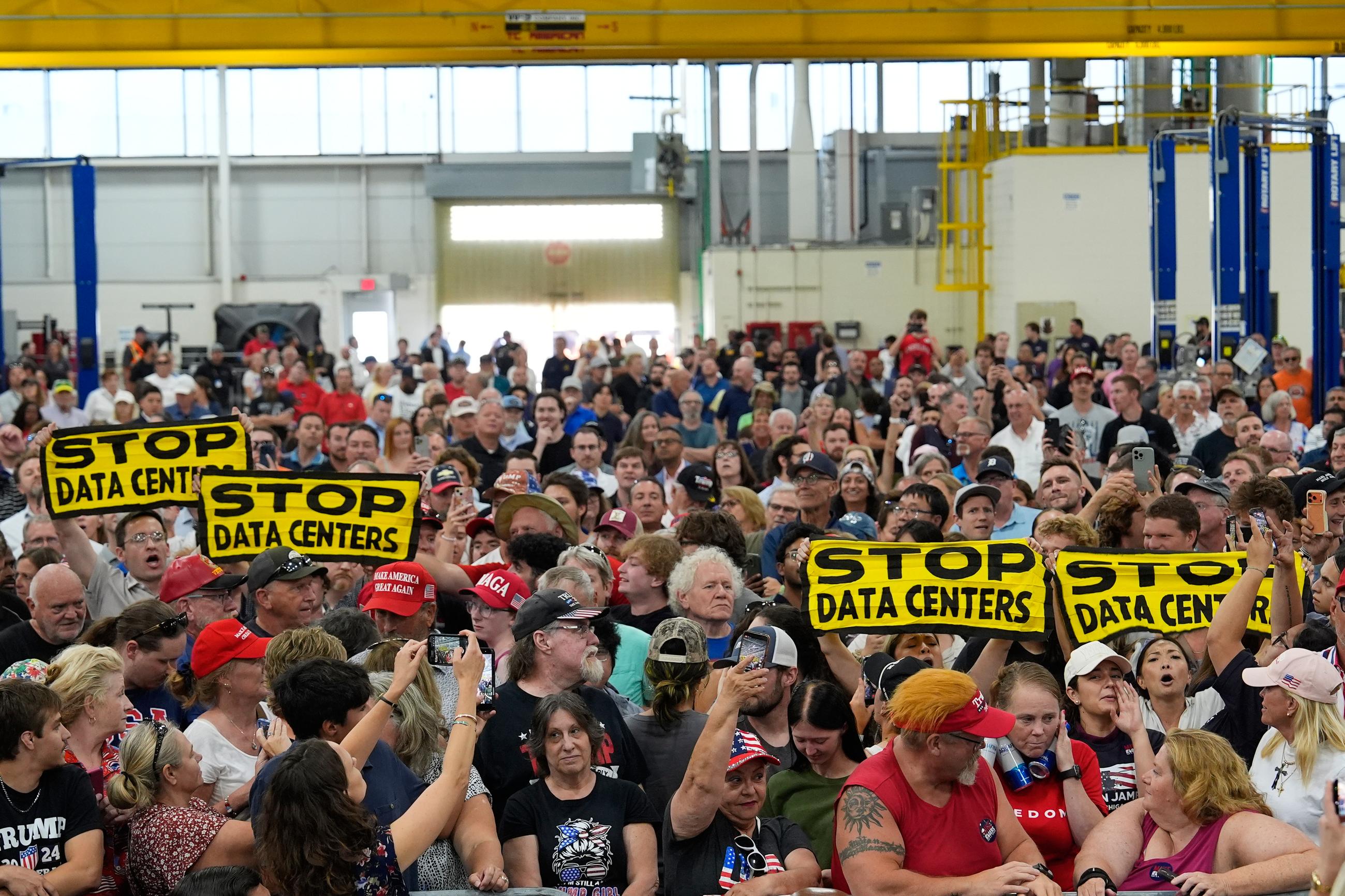 People wait for President Trump to arrive at an event at the General Motors Proving Ground in Milford, Mich., on July 27. (AP Photo/Paul Sancya)