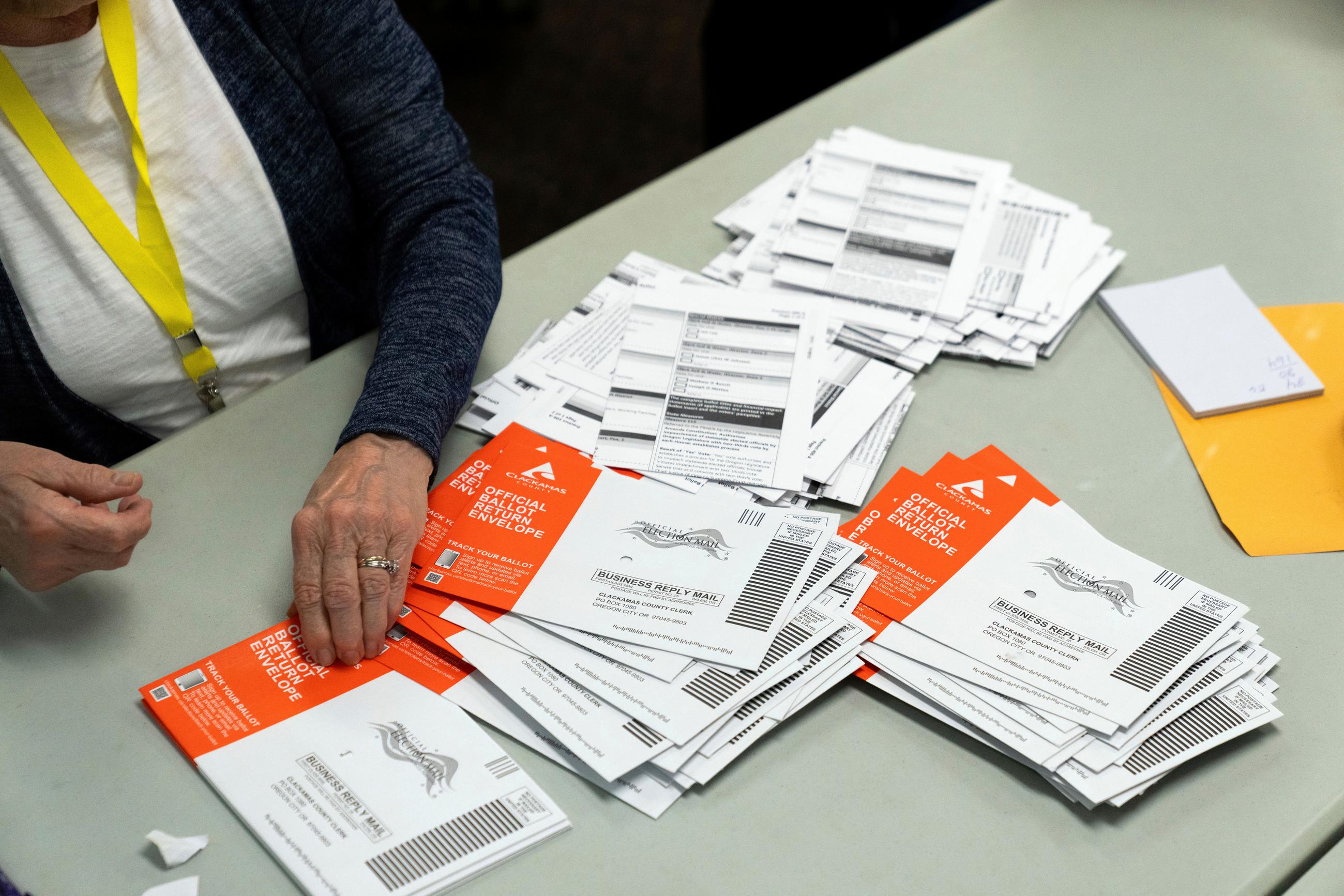 FILE - An election worker reaches for an unopened ballot during sorting at the Clackamas County Elections office, Nov. 7, 2024, in Oregon City, Ore. (AP Photo/Jenny Kane, File)