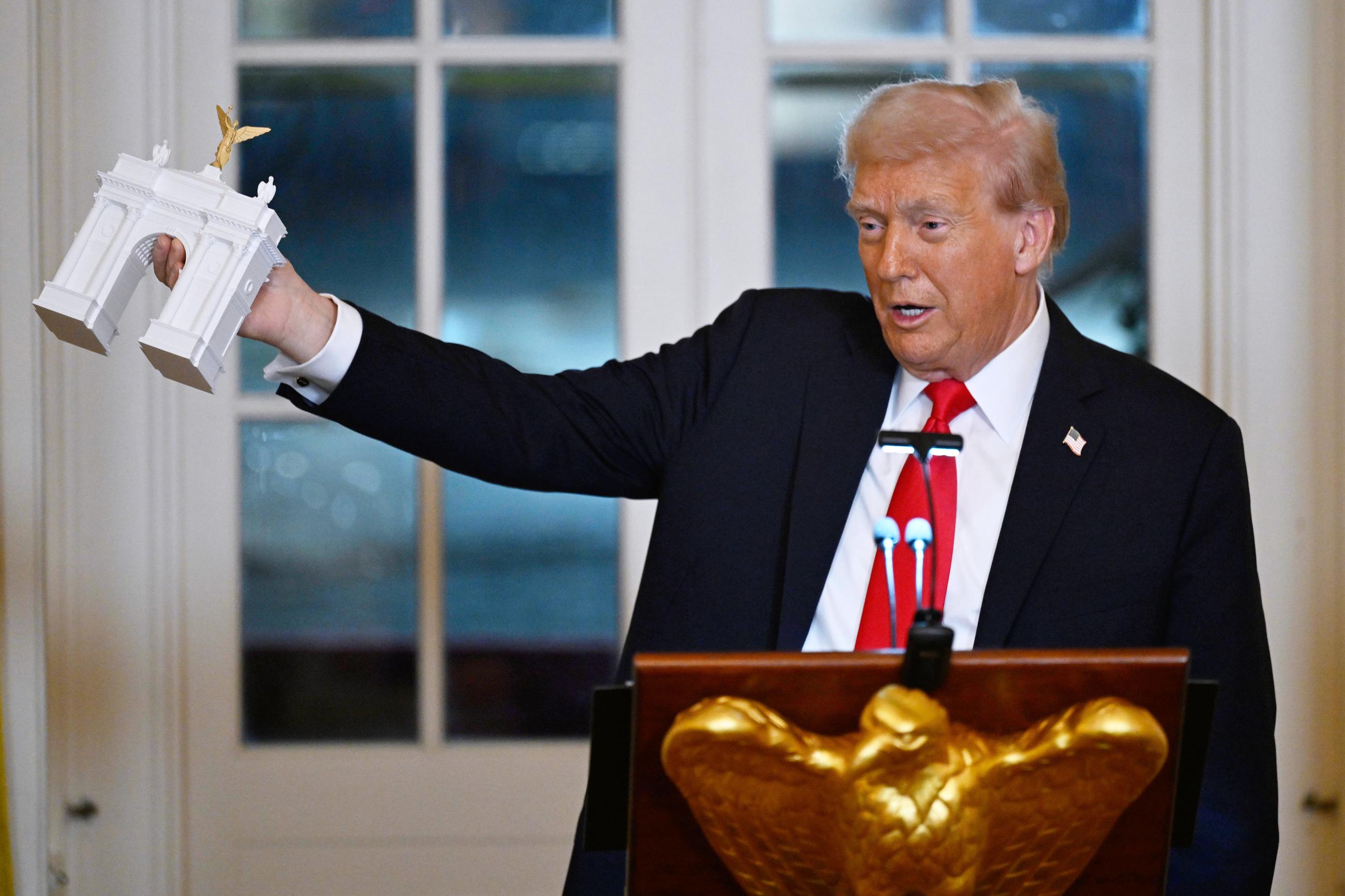 President Trump holds up a model of the proposed triumphal arch at the White House in October 2025. (AP Photo/John McDonnell, File)