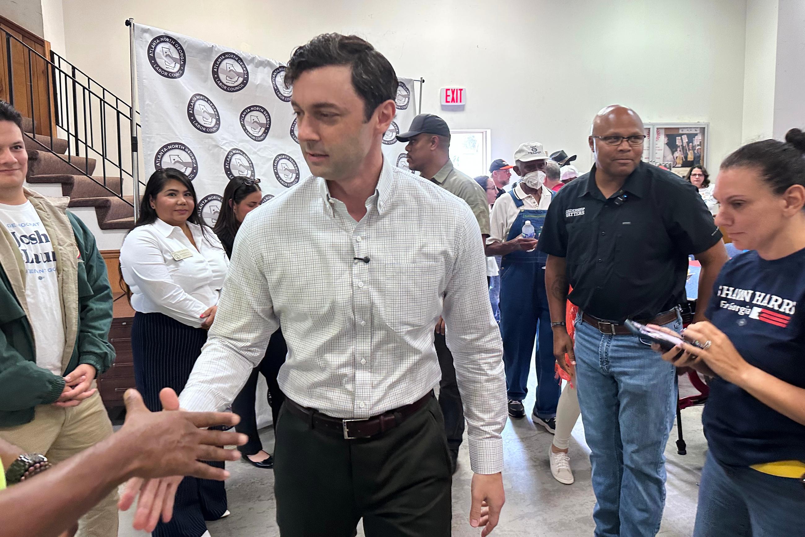 This photo taken with a smartphone shows Sen. Jon Ossoff greeting union members at an Atlanta-North Georgia Labor Council (AFL-CIO) Labor Day lunch in Hapeville, Ga., on Sept. 7. (AP Photo/Bill Barrow)