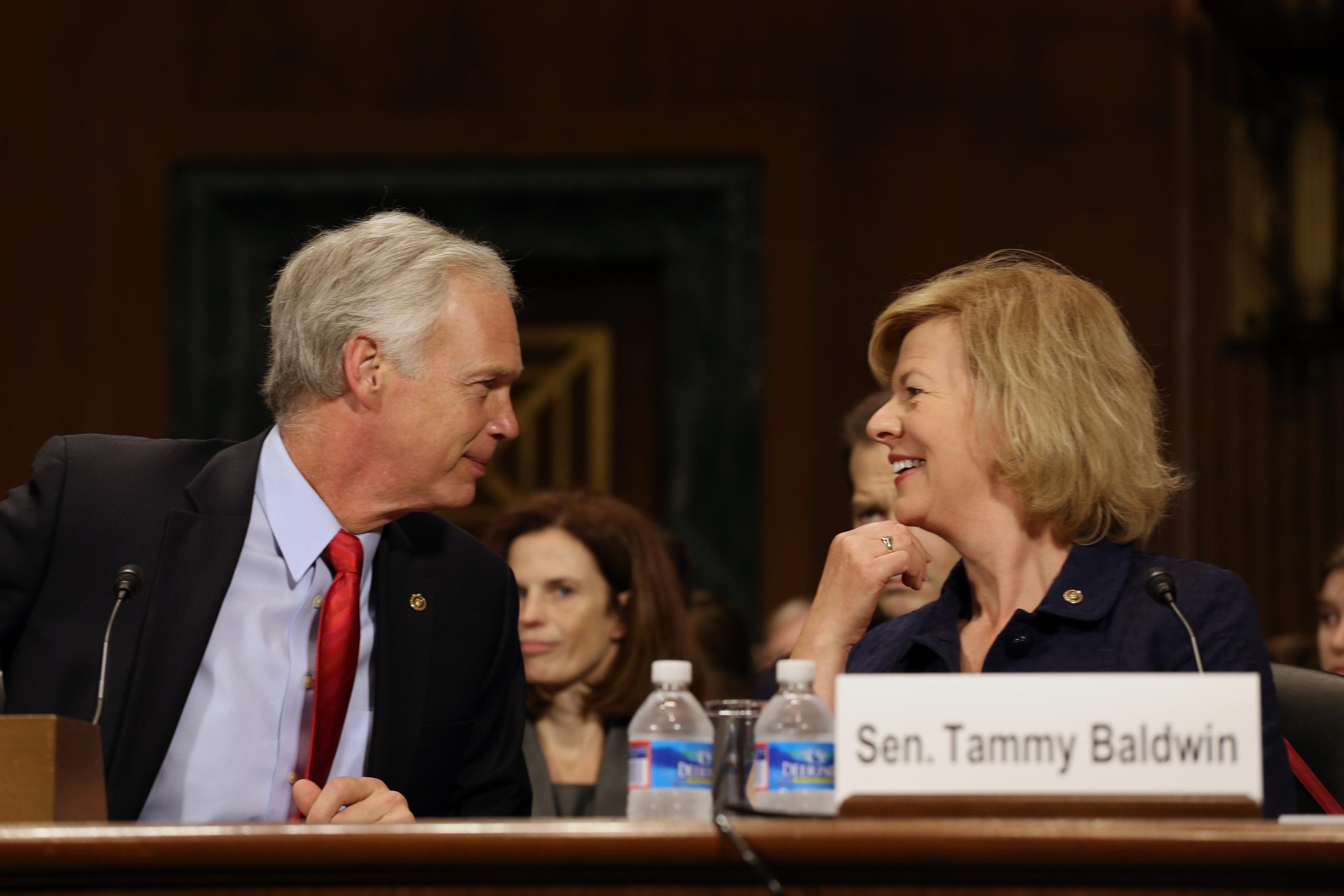 Sen. Ron Johnson, R-Wis., talks with Sen. Tammy Baldwin, D-Wis., on Capitol Hill in Washington, Tuesday, June 24, 2014, before they gave testimony on behalf of Pamela Pepper who is being nominated to be a United States District Judge for the Eastern District of Wisconsin, before the Senate Judiciary Committee. (AP Photo/Harry Hamburg)