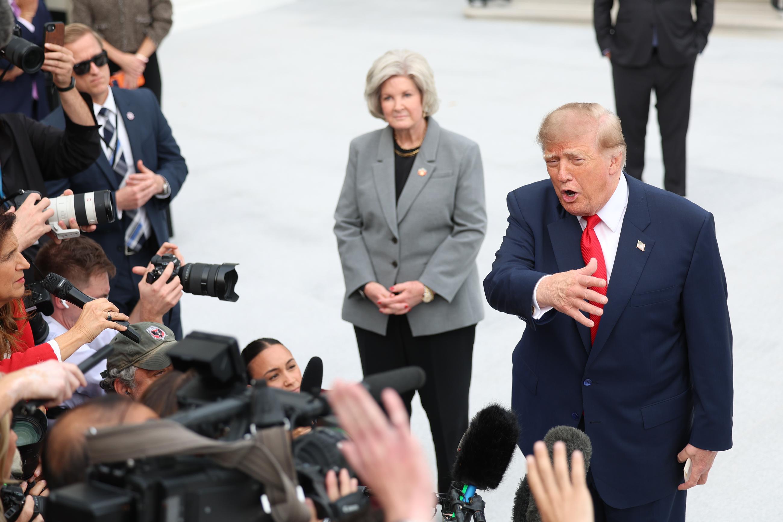 President Trump speaks with reporters as White House Chief of Staff Susie Wiles listens at the White House on Oct. 9. (AP Photo/Tom Brenner)