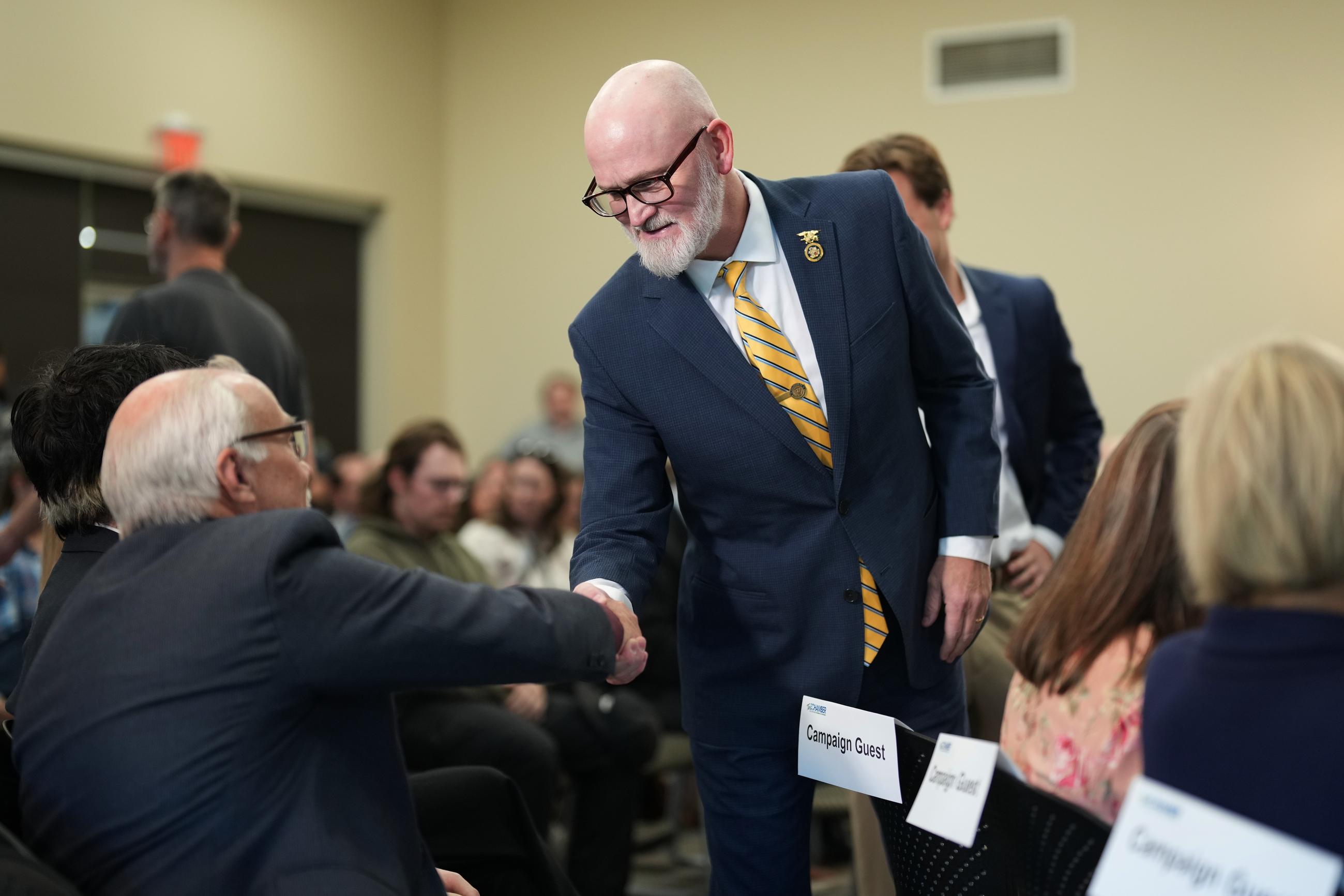 Rep. Derrick Van Orden, R-Wis., a candidate for Wisconsin's 3rd Congressional district, shakes an attendee's hand before a debate with his opponent, Democratic candidate Rebecca Cooke, Tuesday, Oct. 20, 2026, in Eau Claire, Wis. (AP Photo/Ellen Schmidt)